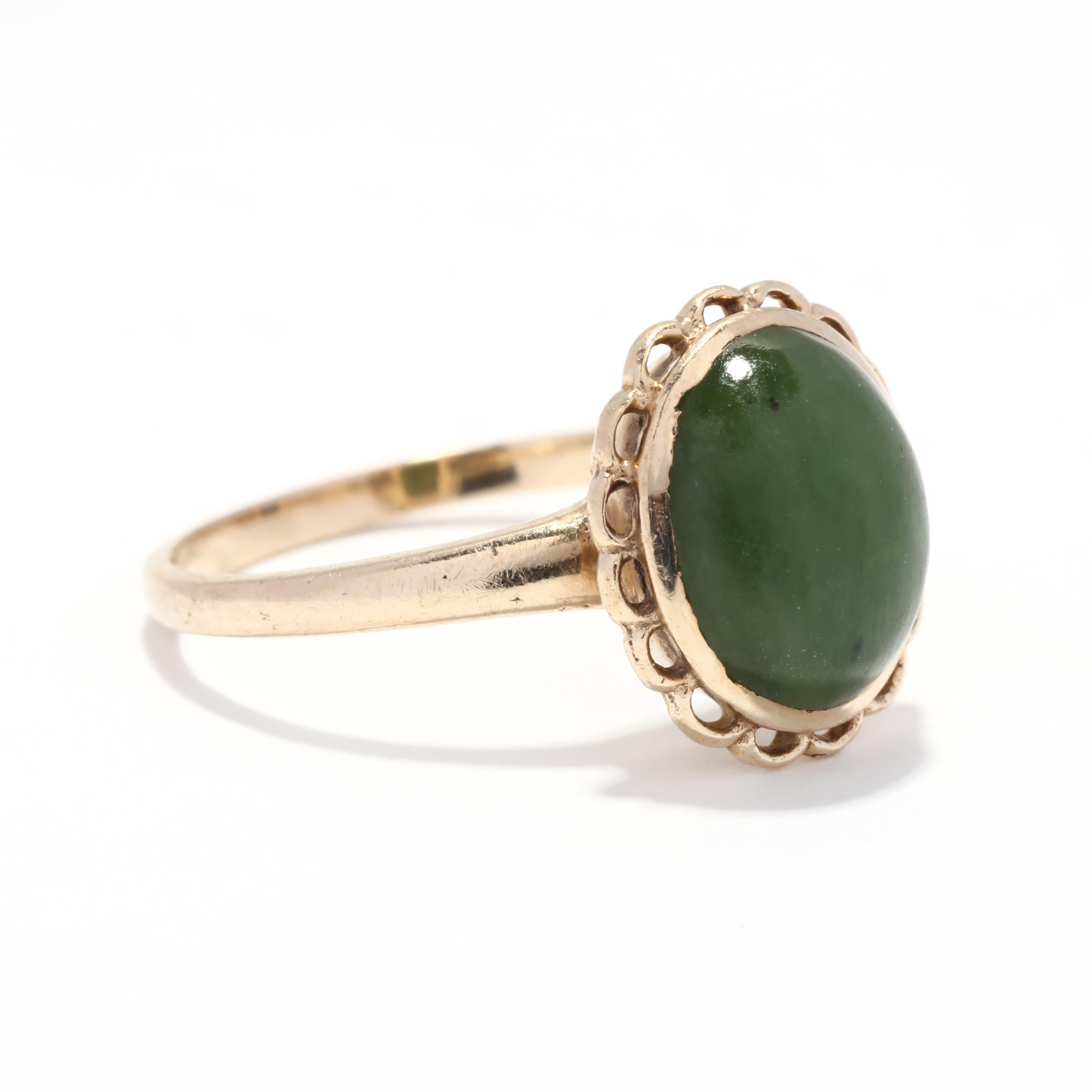 A 1960's vintage 10 karat yellow gold oval nephrite ring. This ring features a bezel set, oval cabochon nephrite stone surrounded by flower ribbon motif and with a thin band.

Stones:
- nephrite, 1 stone
- oval cabochon
- 9.9 x 8.15 x 3.43 mm

Ring