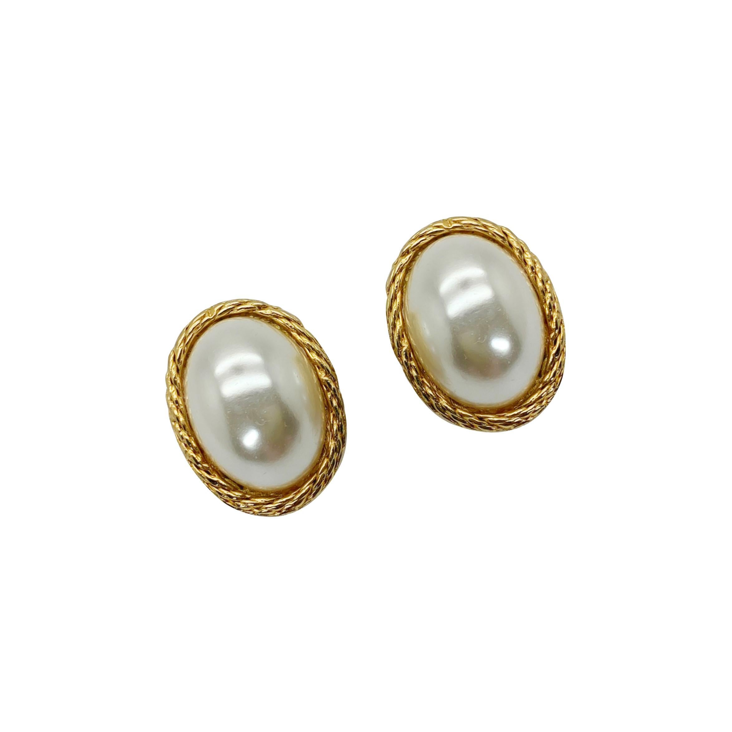 A quintessential pair of vintage oval pearl earrings. Featuring a lustrous oval glass pearl in a contrasting gold rope style setting. 
Vintage Condition: Very good without damage or noteworthy wear. 
Materials: Gold plated metal, glass faux