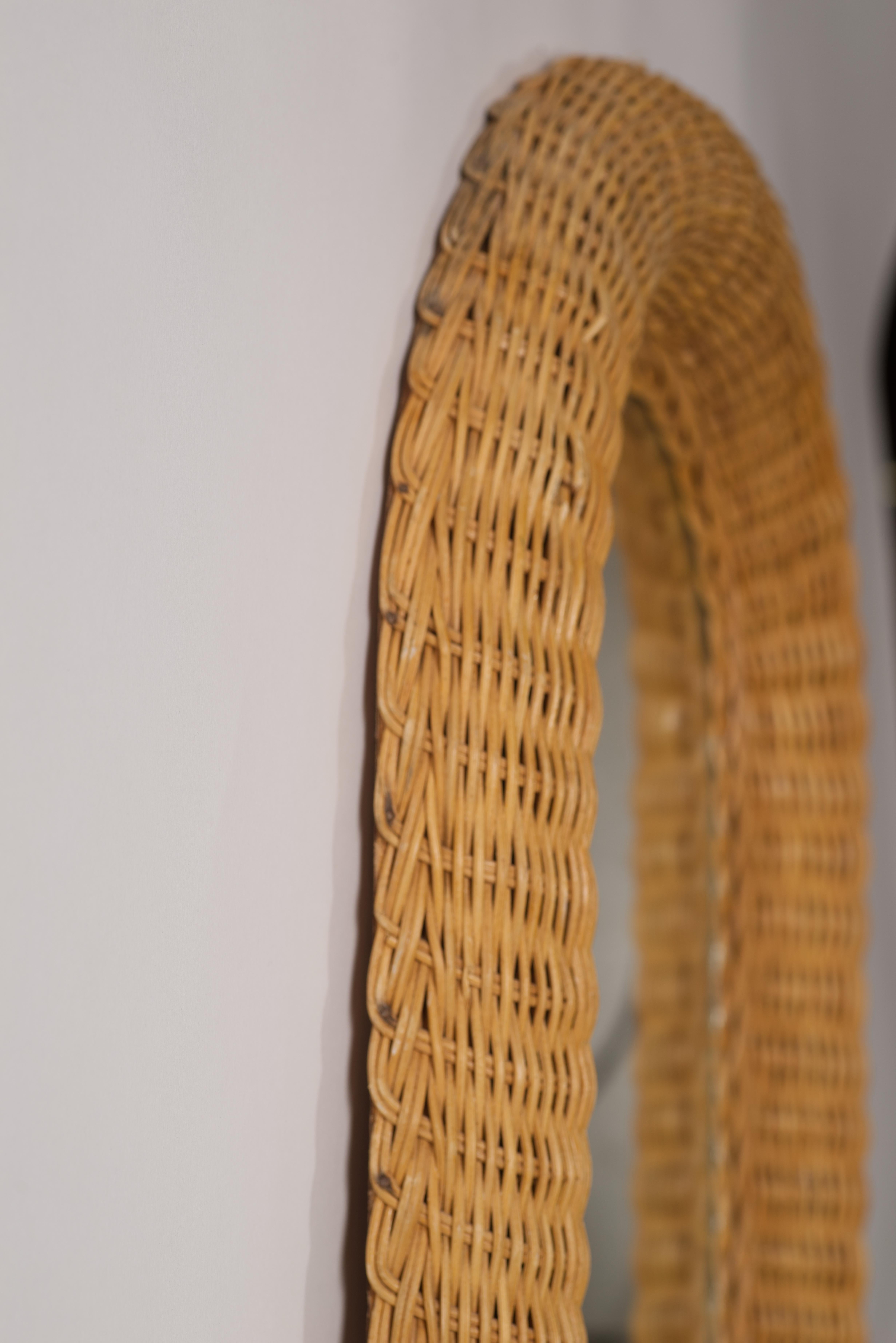  Lo specchio vintage in rattan e vimini intrecciato a mano di forma ovale presenta un accento artigianale intrecciato che separa la cornice dallo specchio, aggiungendo consistenza e interesse visivo. 

Il design in stile French Country, l'intreccio