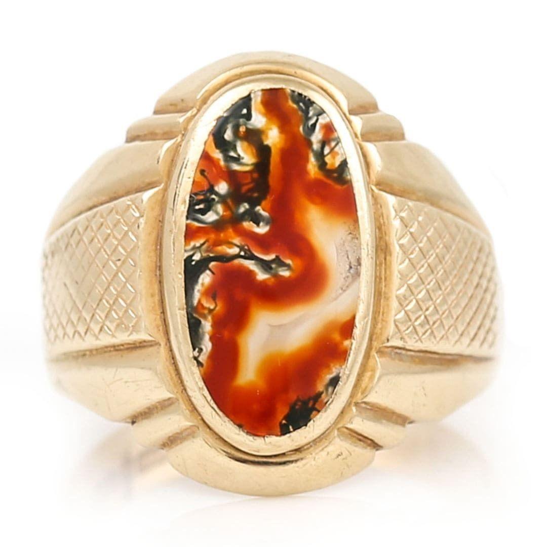 A large and striking unisex red and green moss agate signet ring dating from the 1960s. Set in 9ct yellow gold the natural oval moss agate shows a beautiful marbling of orangish reds and deep greens creating a miniature landscape of flowing colours.