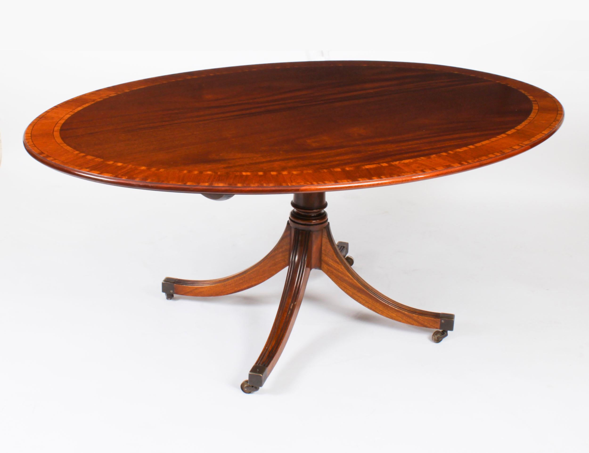 This is a beautiful Regency Revival flame mahogany and satinwood banded oval dining table together with a set of Hepplewhite dining chairs, dating from Circa 1980 and  made by the Master Cabinet maker William Tillman and bearing his label on the