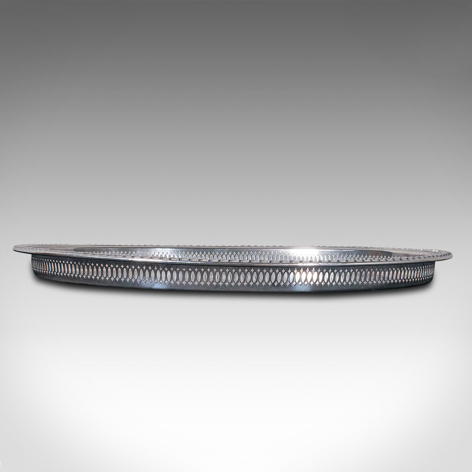 This is a vintage oval serving tray. An English, silver plated afternoon tea platter, dating to the mid 20th century, circa 1950.

Profusely detailed and ornate in appearance
Displays a desirable aged patina throughout
Bright silver plate