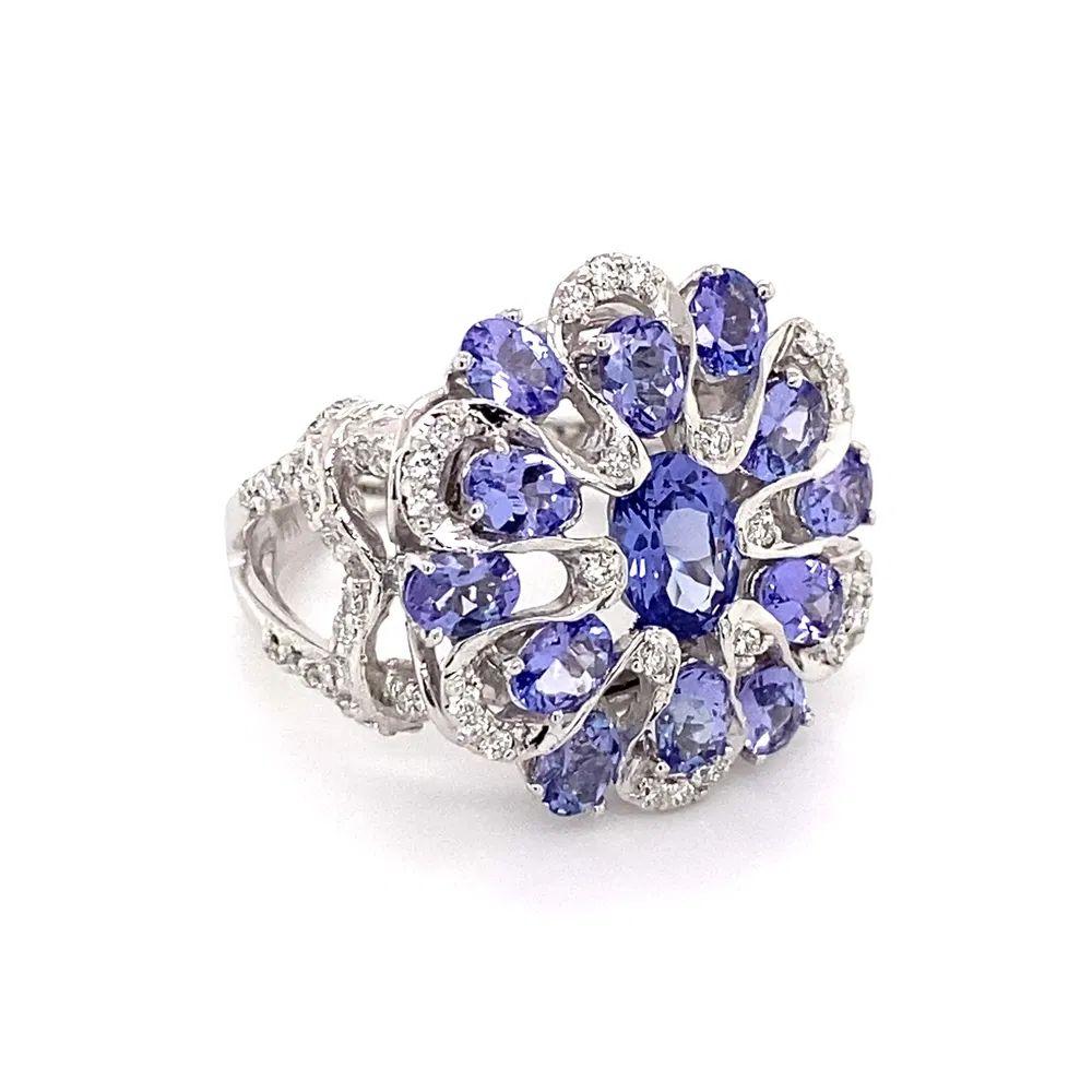 Simply Beautiful! Oval Tanzanite and Diamond Gold Cluster Ring. Hand set with Oval Tanzanite, weighing approx. 1.30tcw, inter-spaced with Diamonds, approx. 0.30tcw. The ring is skillfully encased in Hand crafted 14K White Gold mounting. Measuring