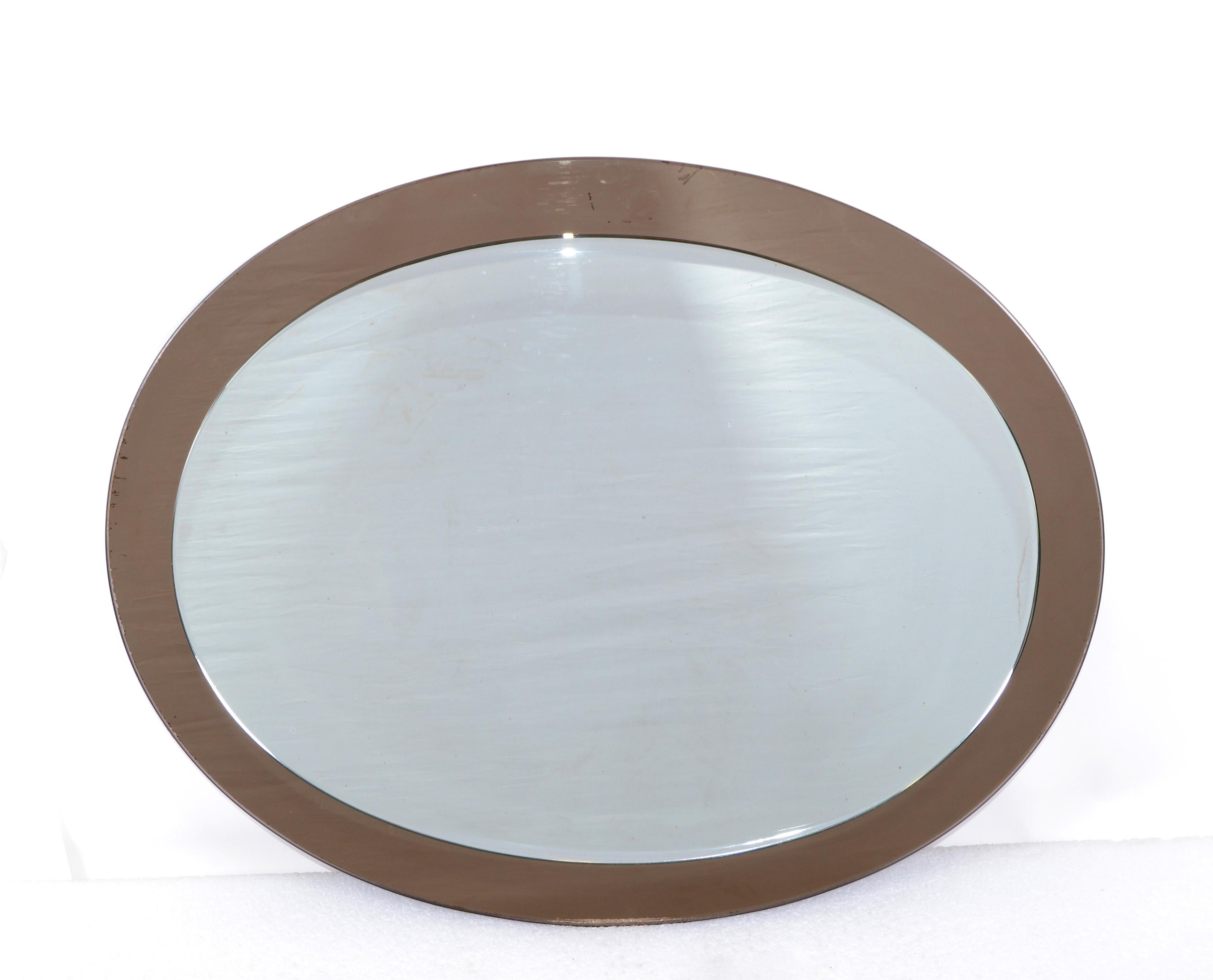 Mid-Century Modern oval beveled Italian wall mirror by Veca circa 1960s.
The back is smoke brown mirror with a regular clear mirror on the top (23 H x 17 inches Width).
Can be hung horizontal or vertical.