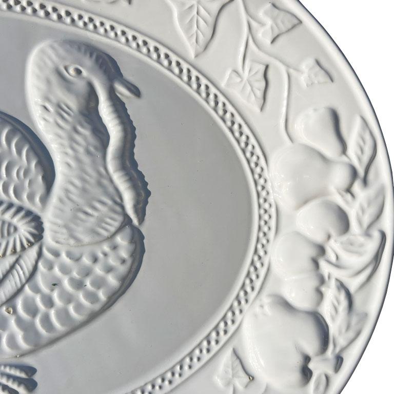 ¡Esta fuente festiva vintage será perfecta para una mesa navideña! Está hecha de cerámica y esmaltada en un blanco cremoso. La parte superior está decorada con un diseño de cosecha en relieve que incluye maíz, uvas, manzanas y un pavo en el centro.