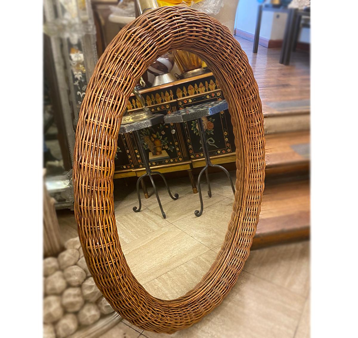 An English circa 1970's oval mirror with wicket frame.

Measurements:
Height: 39