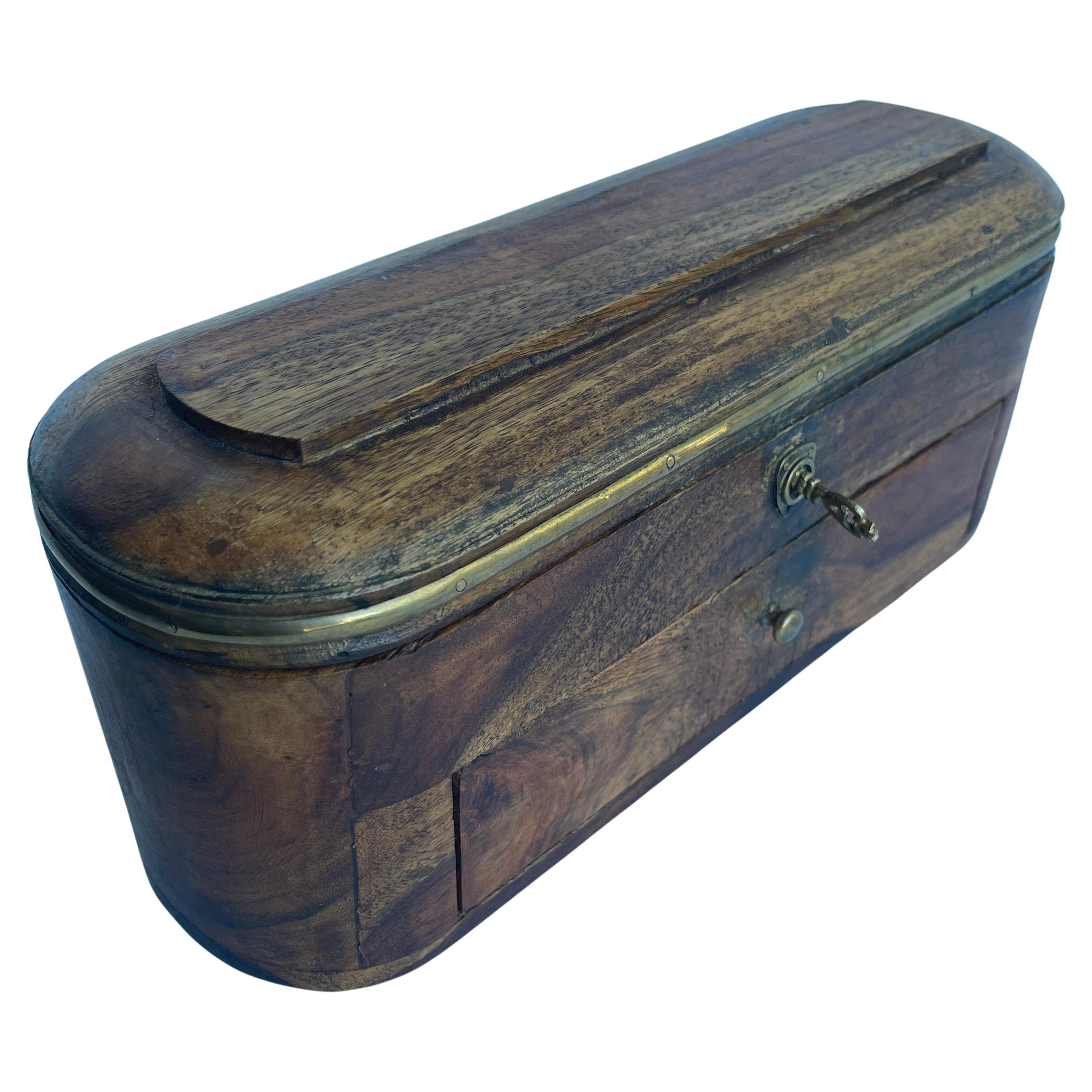 Vintage Holz und Messing getrimmt Box mit Schloss und original Hardware und Schlüssel.
Die geschwungenen Ecken, die mit einer Patina aus gealtertem Messing verziert sind, unterstreichen den Charakter dieses Schatzkästchens. Groß genug, um Schmuck