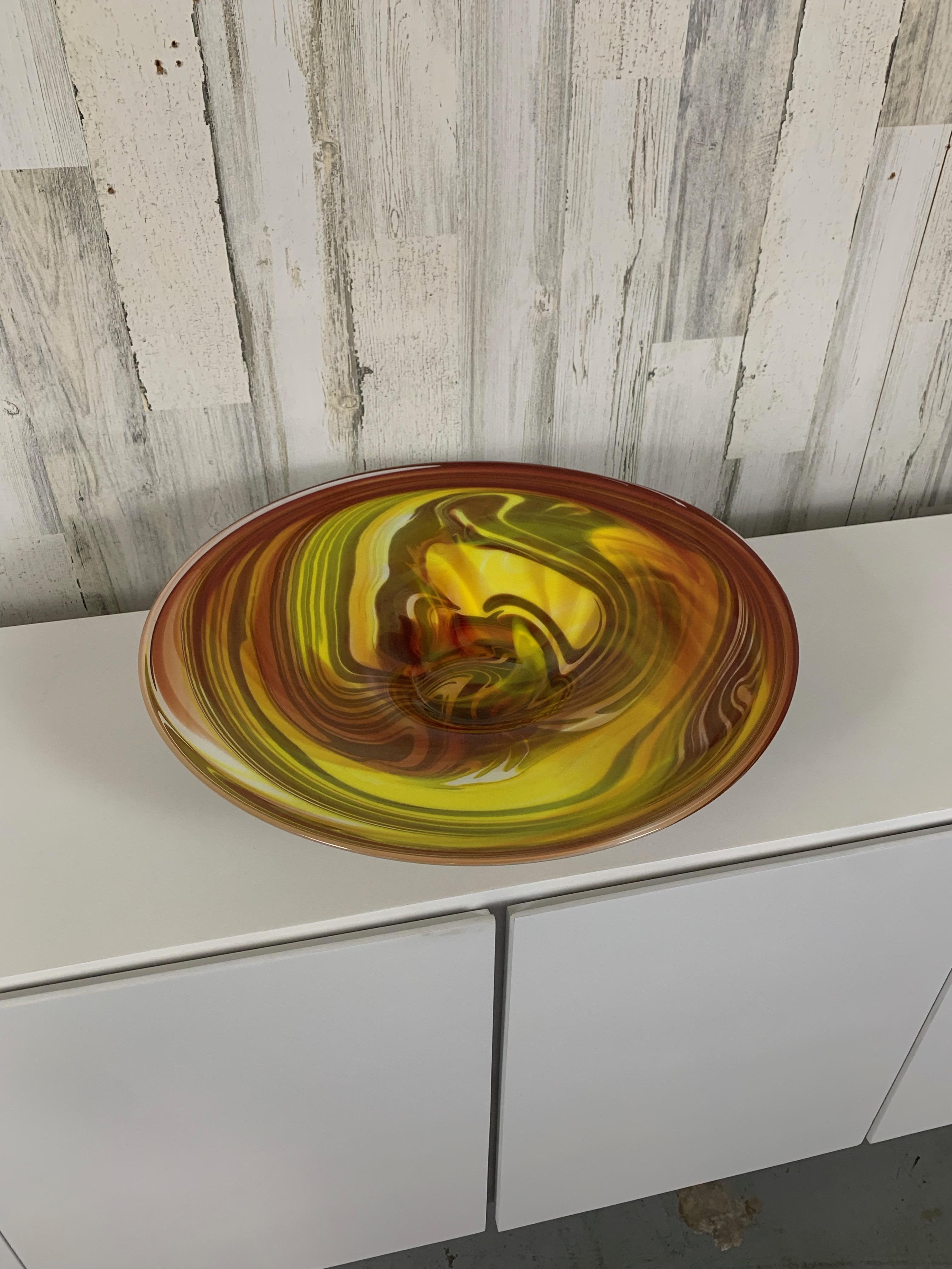 Caricatore in vetro artistico soffiato a mano con design a vortice di colore giallo, verde e salmone. Può essere utilizzata come ciotola o esposta su un cavalletto con una luce posteriore.
