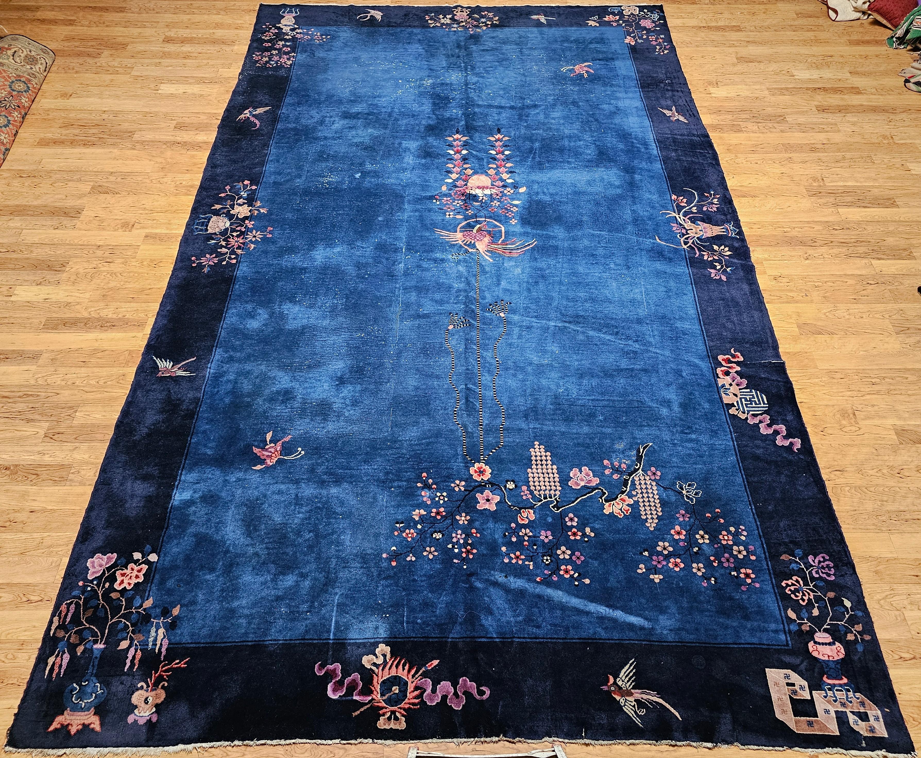 Elegante, rara y rica en simbolismo cultural, esta alfombra Art Decó china de principios del siglo XX presenta un llamativo campo azul francés enmarcado por un profundo borde azul marino, creando una sofisticada y serena paleta de colores que eleva