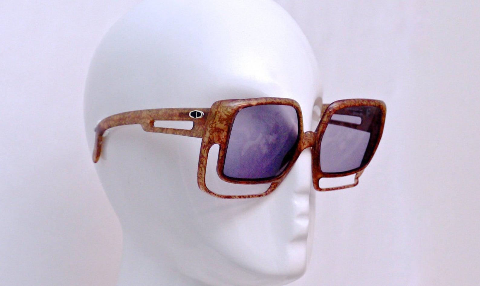 Vintage Oversize Christian Dior Space Age Brown Sunglasses

Measurements:
Height: 2 5/8 inches
Horizontal Width: 6 inches
Temples: 5 inches

Features:
- 100% Authentic Vintage CHRISTIAN DIOR.
- Oversized space age sunglasses.
- Marbled brown colour