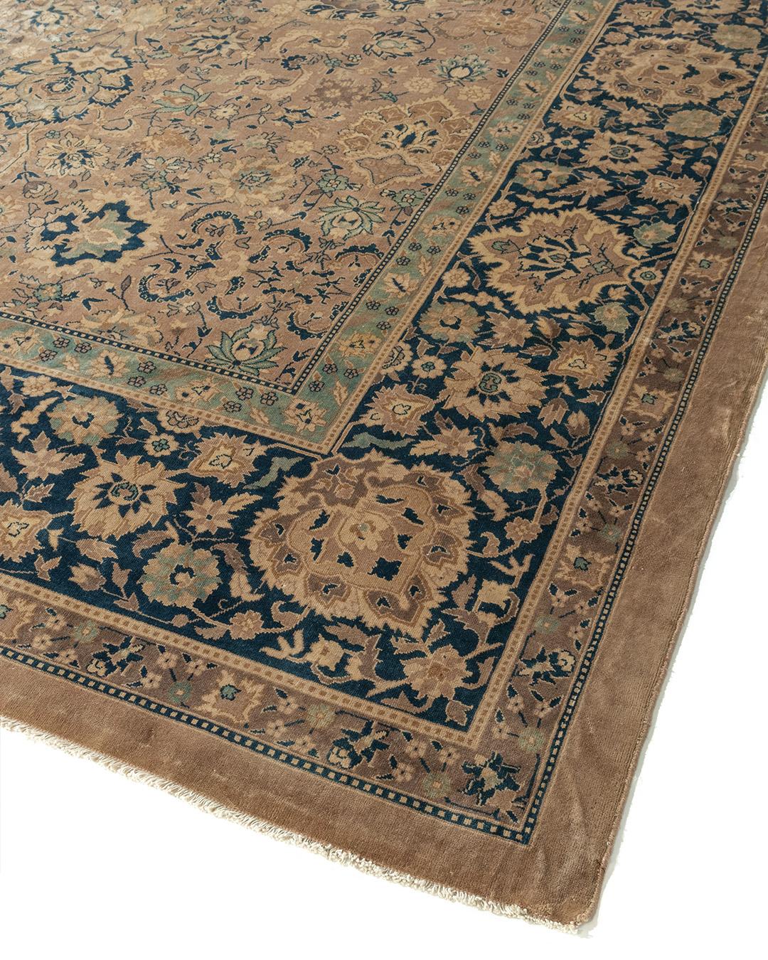 Antique oversize Indo Kirman rug, 14'7 x 23'9. Very intricate poly-chromatic floral patterns cover the tan central field and are surrounded by a Persian blue border with complex floral designs.
