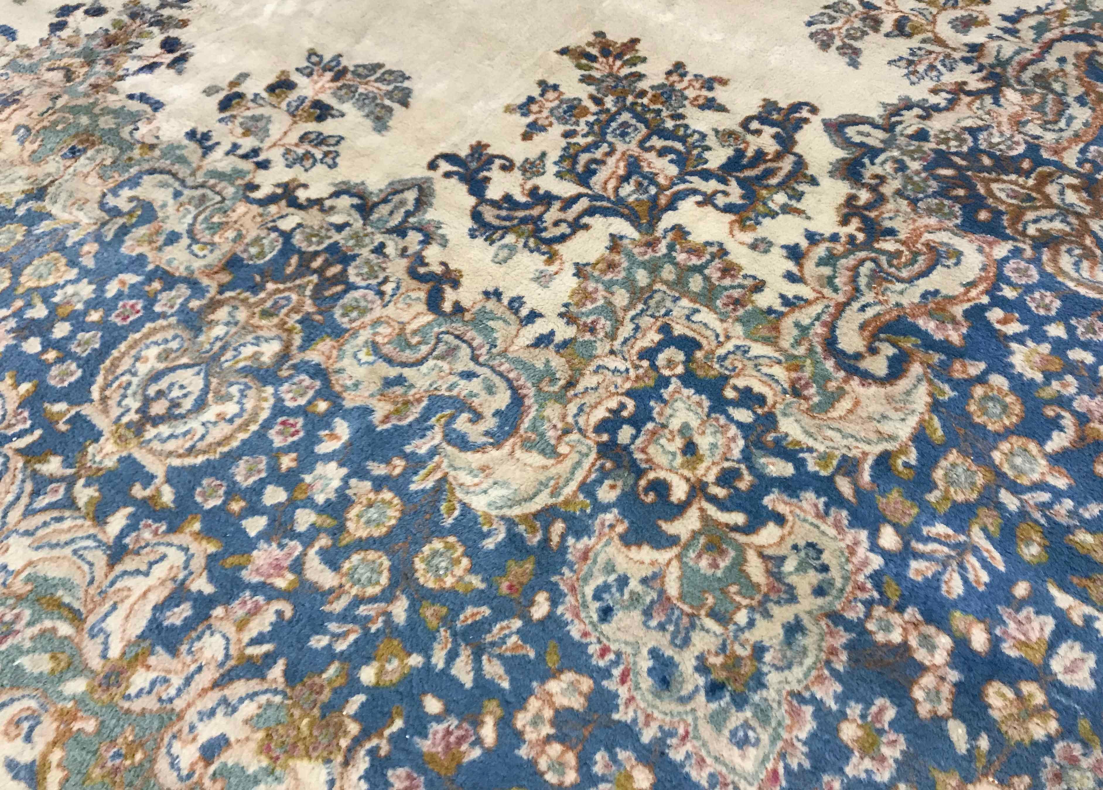Vintage oversize Kerman rug, circa 1940. This attractive oversized Kerman has an ivory ground enclosing a central floral design in soft pastel blues with a floral theme surrounding the central field, the main border continues the soft blue colors