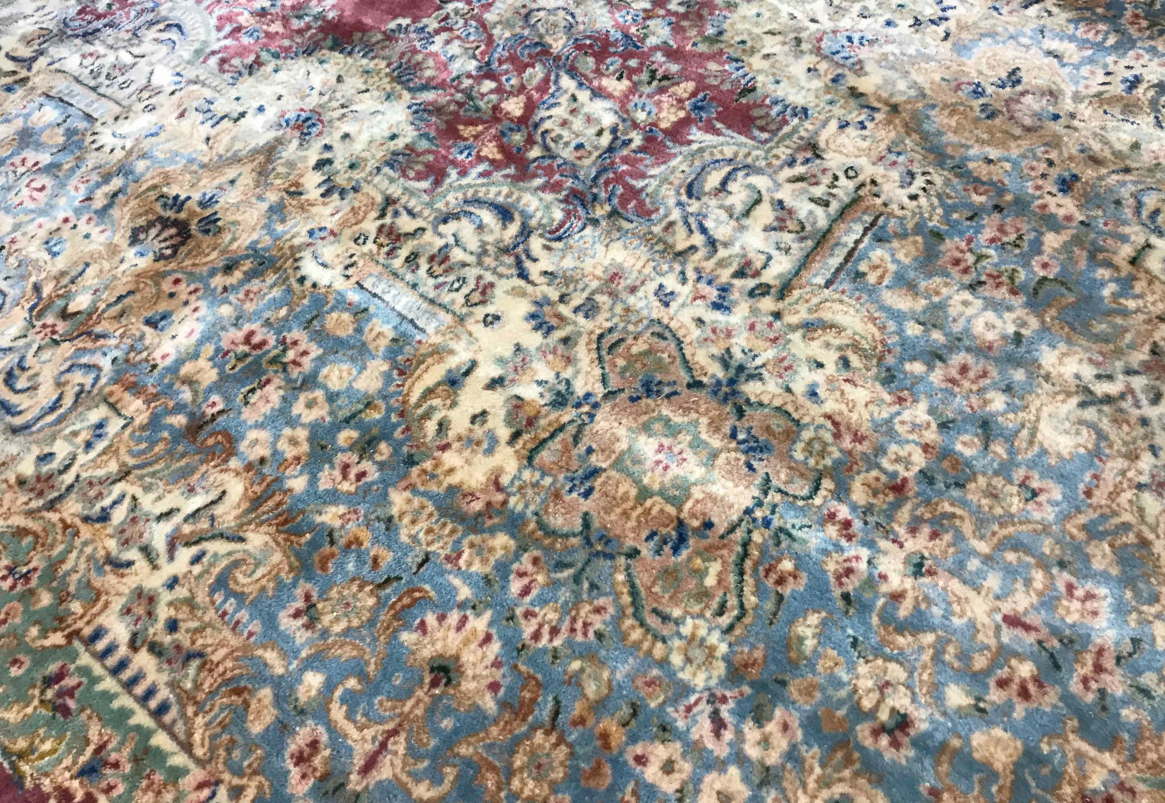 Vintage oversize Kerman rug, circa 1940. This dramatic looking oversize Kerman has a central soft plum field containing a floral design medallion all enwrapped within a soft blue and ivory border overflowing into the main design to create a look of