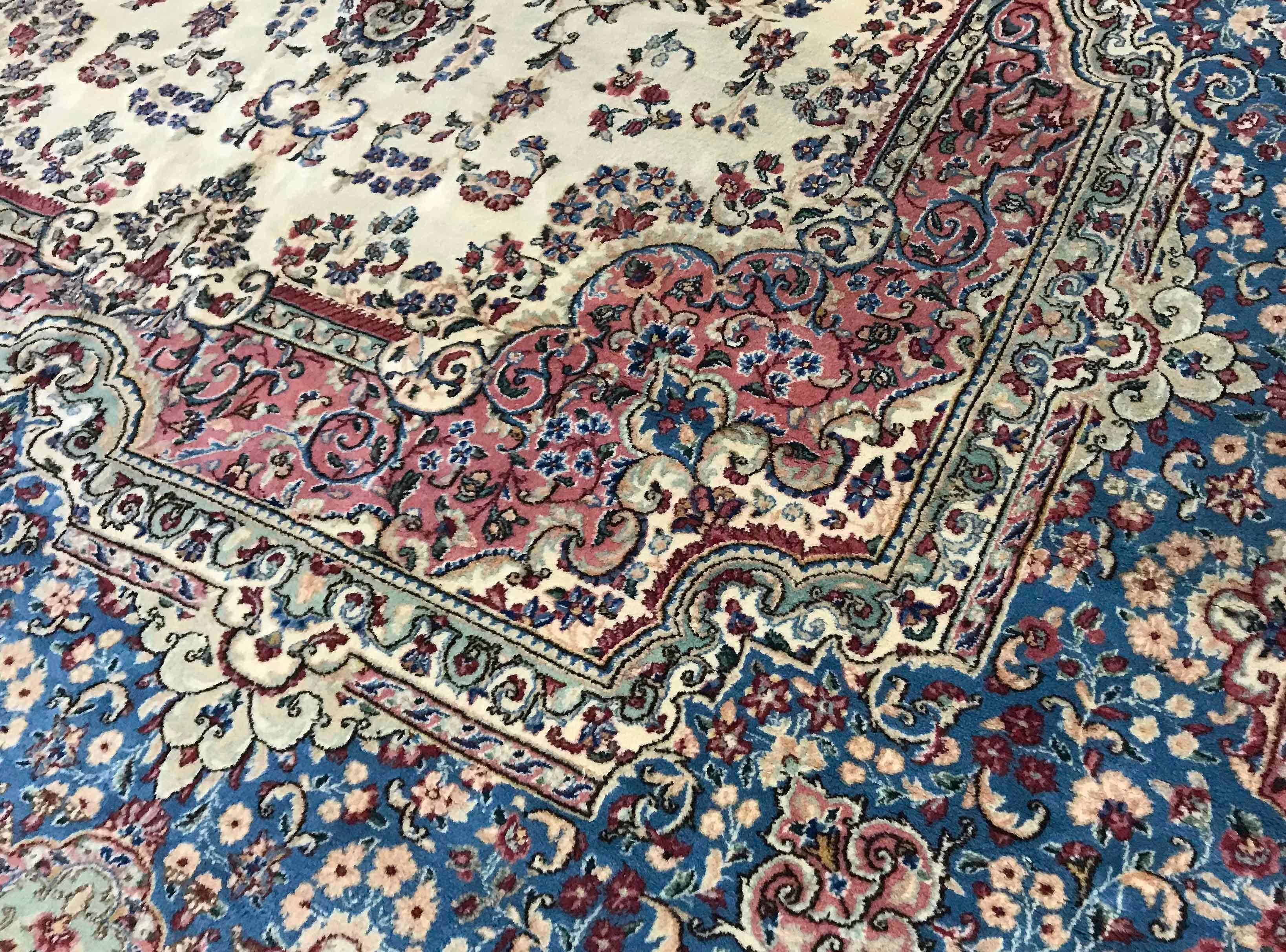 Vintage Persisch Kerman, um 1940. Dieser attraktive, übergroße Kerman hat einen elfenbeinfarbenen Grund, der ein zentrales Blumenmuster in zarten Pastellblau umschließt. Das florale Thema umgibt das zentrale Feld und die Hauptbordüre setzt die