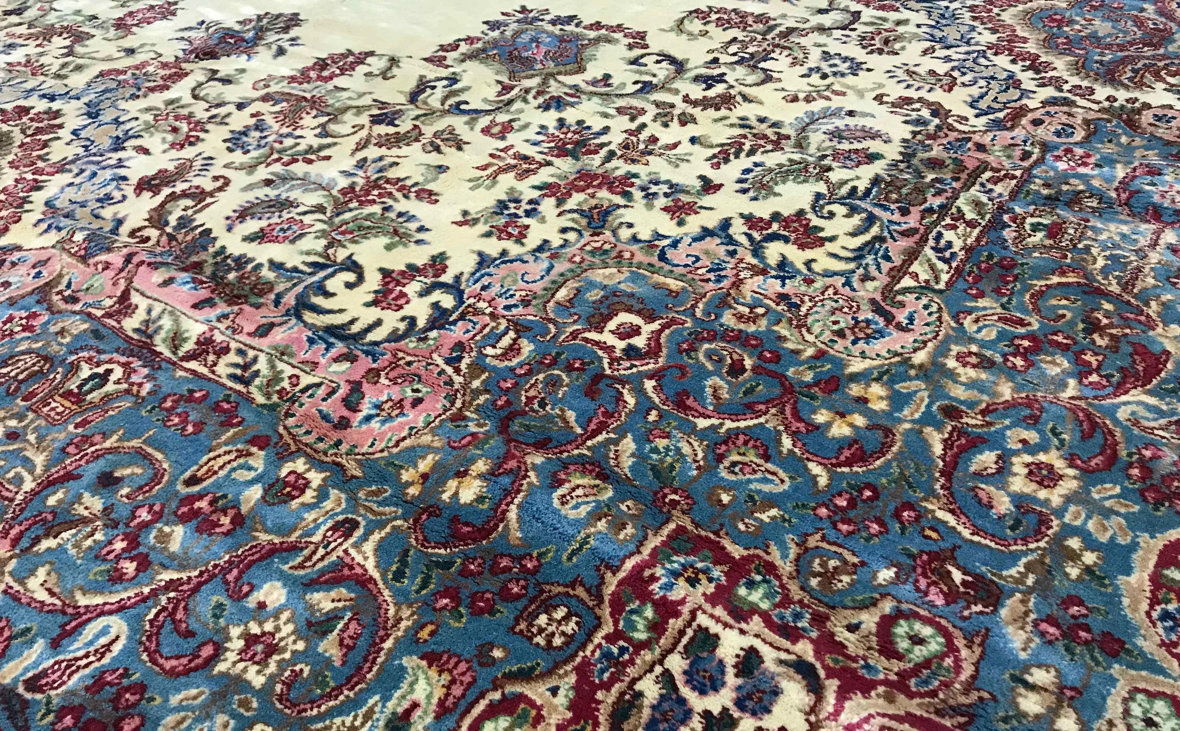 Übergroßer persischer Kerman-Teppich, um 1940. Der weiche elfenbeinfarbene Grund ist der Rahmen für diesen malerischen Teppich mit einem zentralen Medaillon, dessen blaue Farben und Stil sich in den Bordüren wiederholen, um dieses große, aber sanft