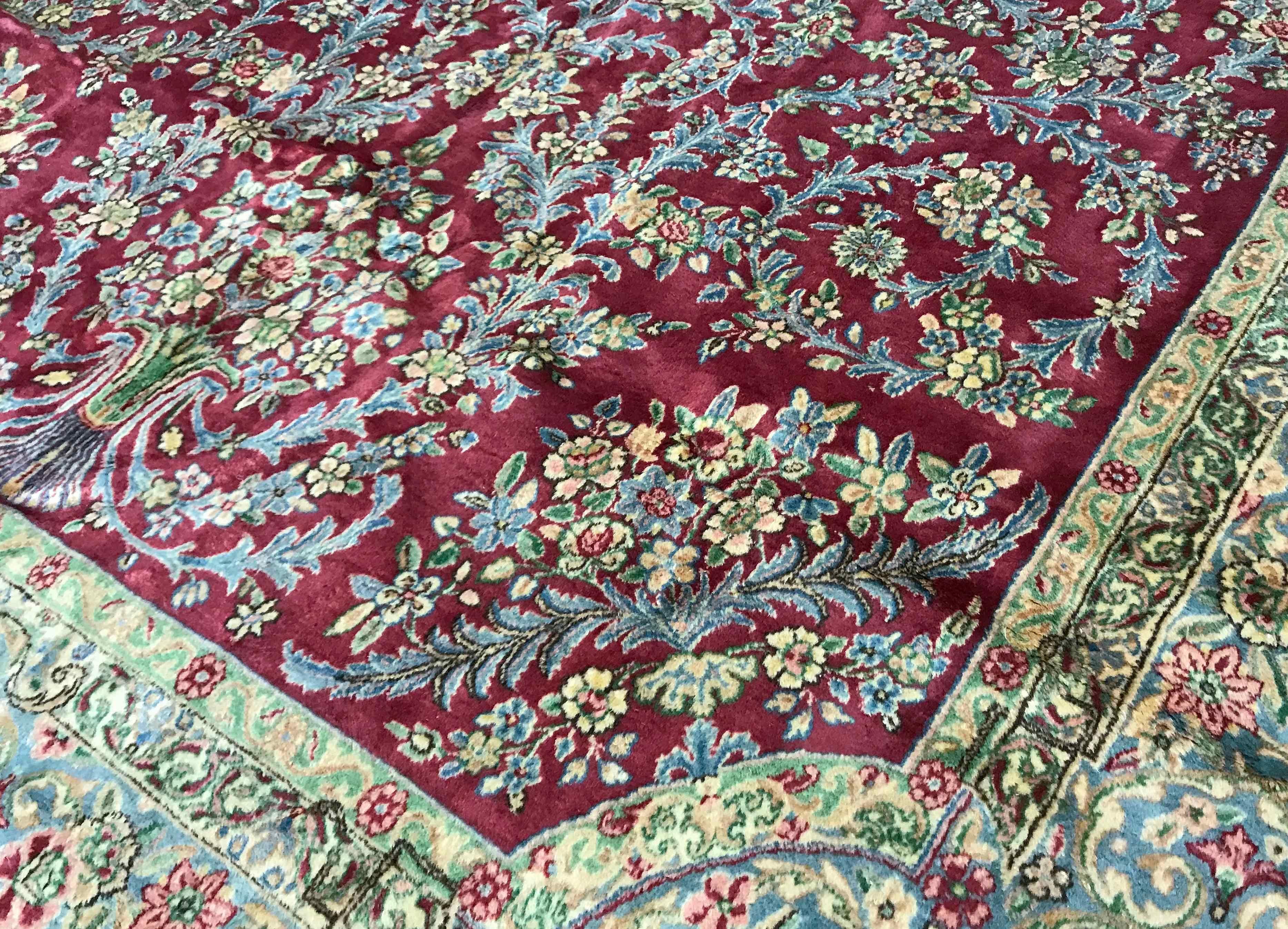 Persischer Kerman-Teppich in Übergröße, um 1940. Auf einem schönen roten Grund, der mit Blumen und Ranken gefüllt ist und ein zentrales Medaillon mit einer Hauptbordüre umgibt, die die floralen Muster wiederholt. Größe: 7'11 x 20'7.