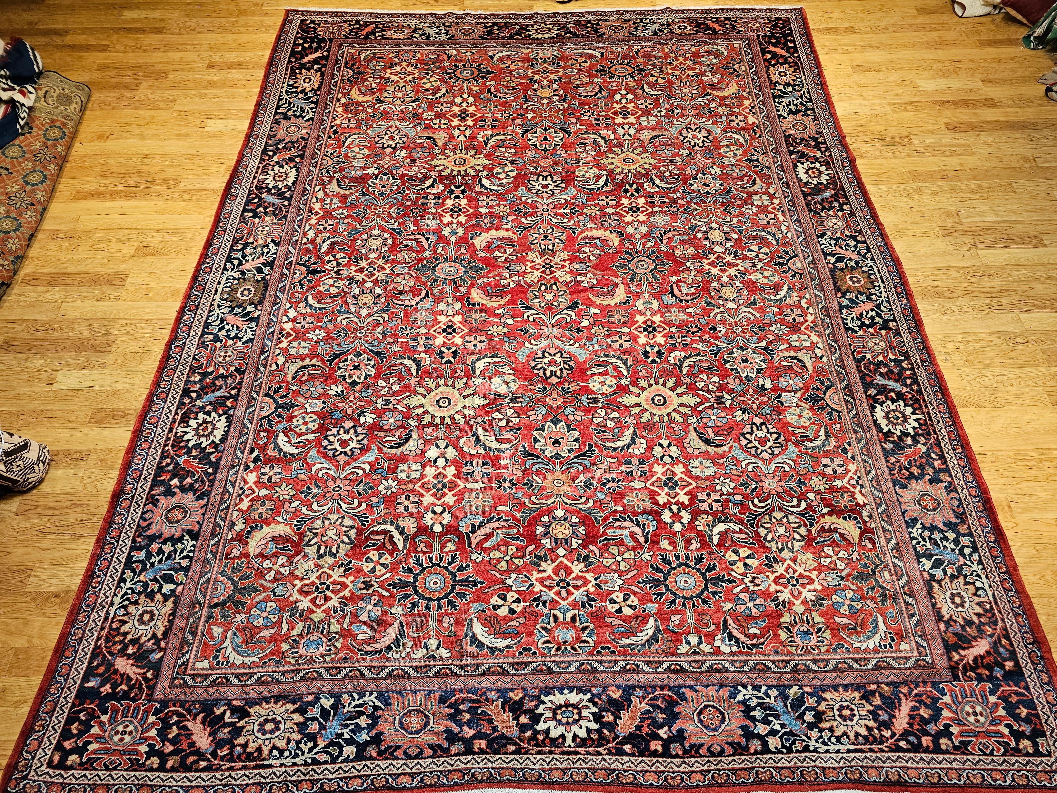 Exemple captivant de l'artisanat persan du début du 20e siècle, ce tapis vintage surdimensionné Mahal Sultanabad présente un étonnant motif géométrique sur fond rouge. Tissé par des artisans qualifiés en Perse, cette pièce incarne magnifiquement