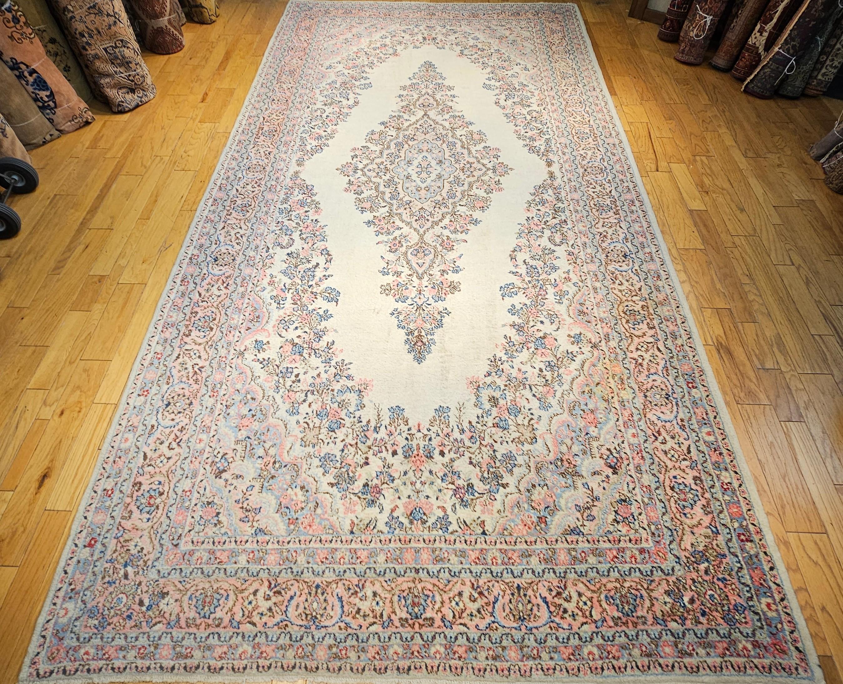 Esta alfombra persa Qazvin vintage de gran tamaño es un asombroso ejemplo de fina artesanía y diseño atemporal, inspirado en la célebre tradición de alfombras Kerman de principios y mediados del siglo XX. Con un suave campo marfil adornado con un