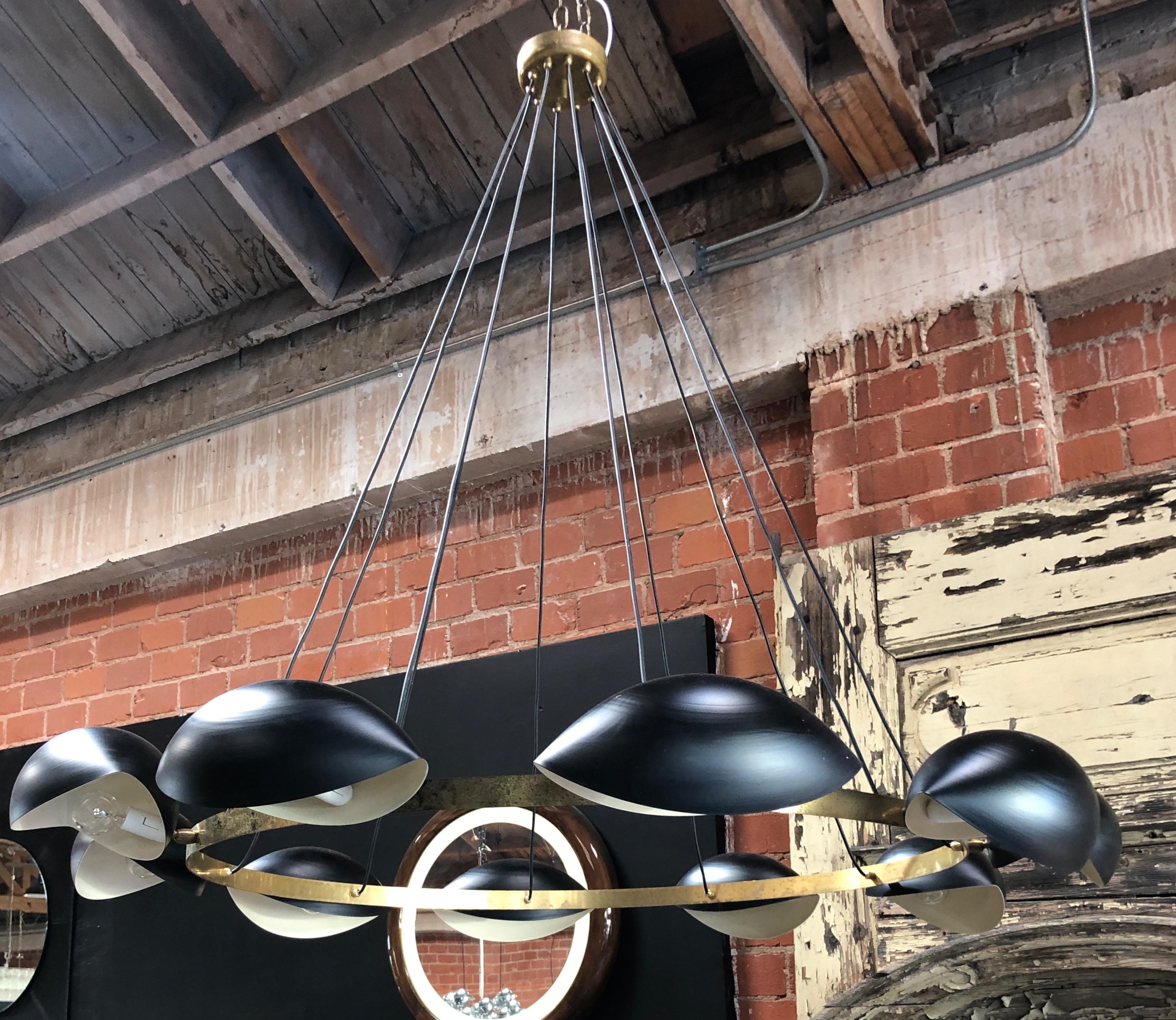 Large round 1960s chandelier: a brass wheel with 8 lights black lacquered bulbs is hanging down from the ceiling, because of its dimensions, this lamp is also suitable for large rooms.
The electrification is checked, you need E 27 (medium Edison