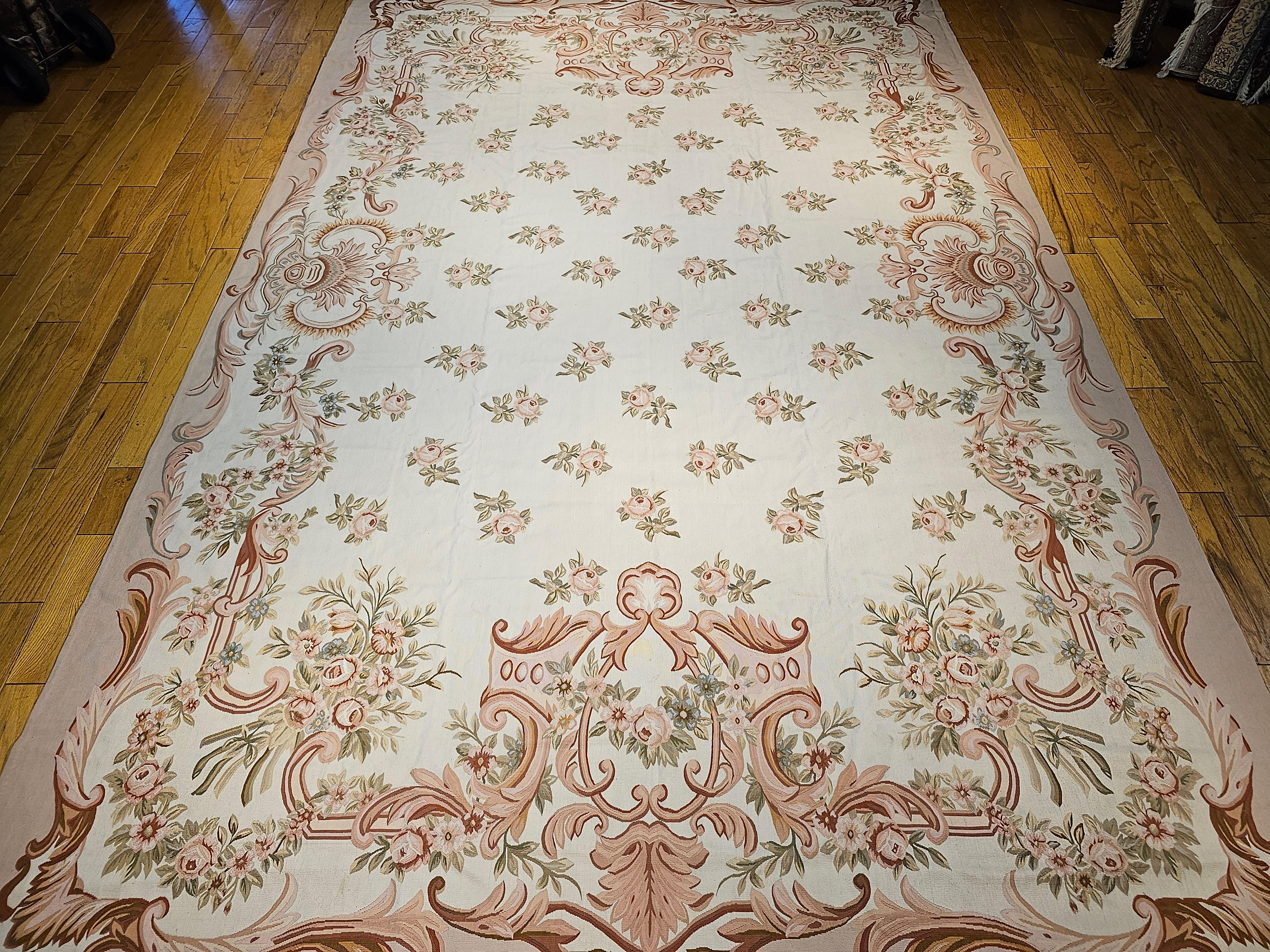 Beautiful Vintage  oversized Aubusson design flat-woven tapestry rug in a simple repeated floral bouquet pattern in light or pale taupe, sage, pale blue, brown, and pale pink.   The vintage oversized tapestry woven rug brings elegance and grandeur