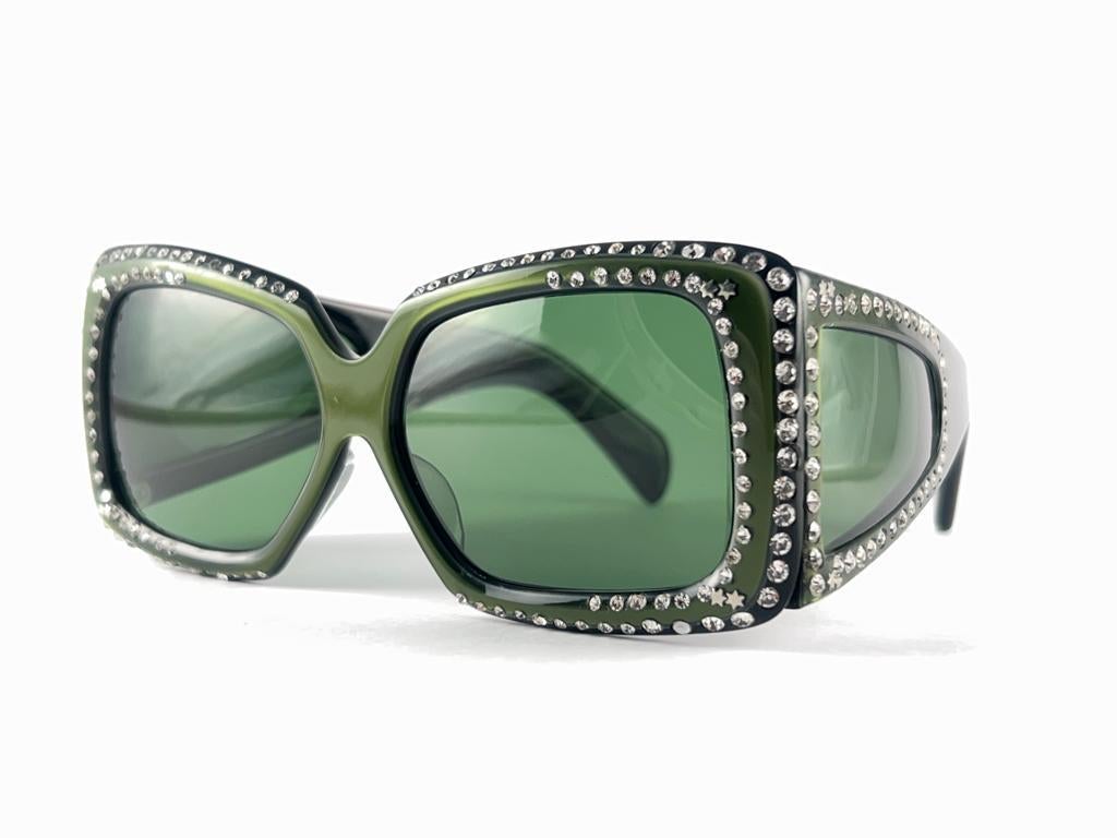Vintage oversized dark green strass adorned sunglasses.

 Please consider that this item is nearly 40 years old so it could show minor sign of wear due to storage.  

Made in France.


FRONT : 14 CMS

LENS HEIGHT : 4 CMS

LENS WIDTH : 5.5 CMS


