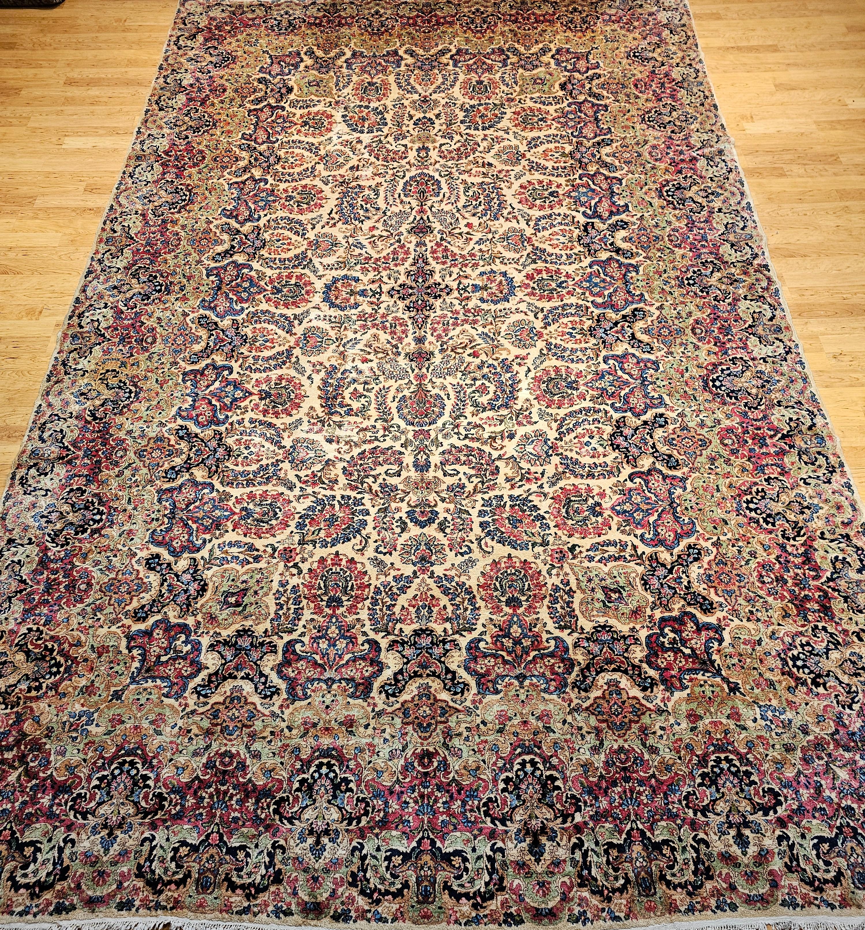 Dieser übergroße persische Kerman-Teppich im Vintage-Stil, der in den frühen 1900er Jahren handgewebt wurde, ist von zeitloser Eleganz. Dieses außergewöhnliche Stück mit seinem raffinierten Blumenbouquet-Design zelebriert die traditionelle persische