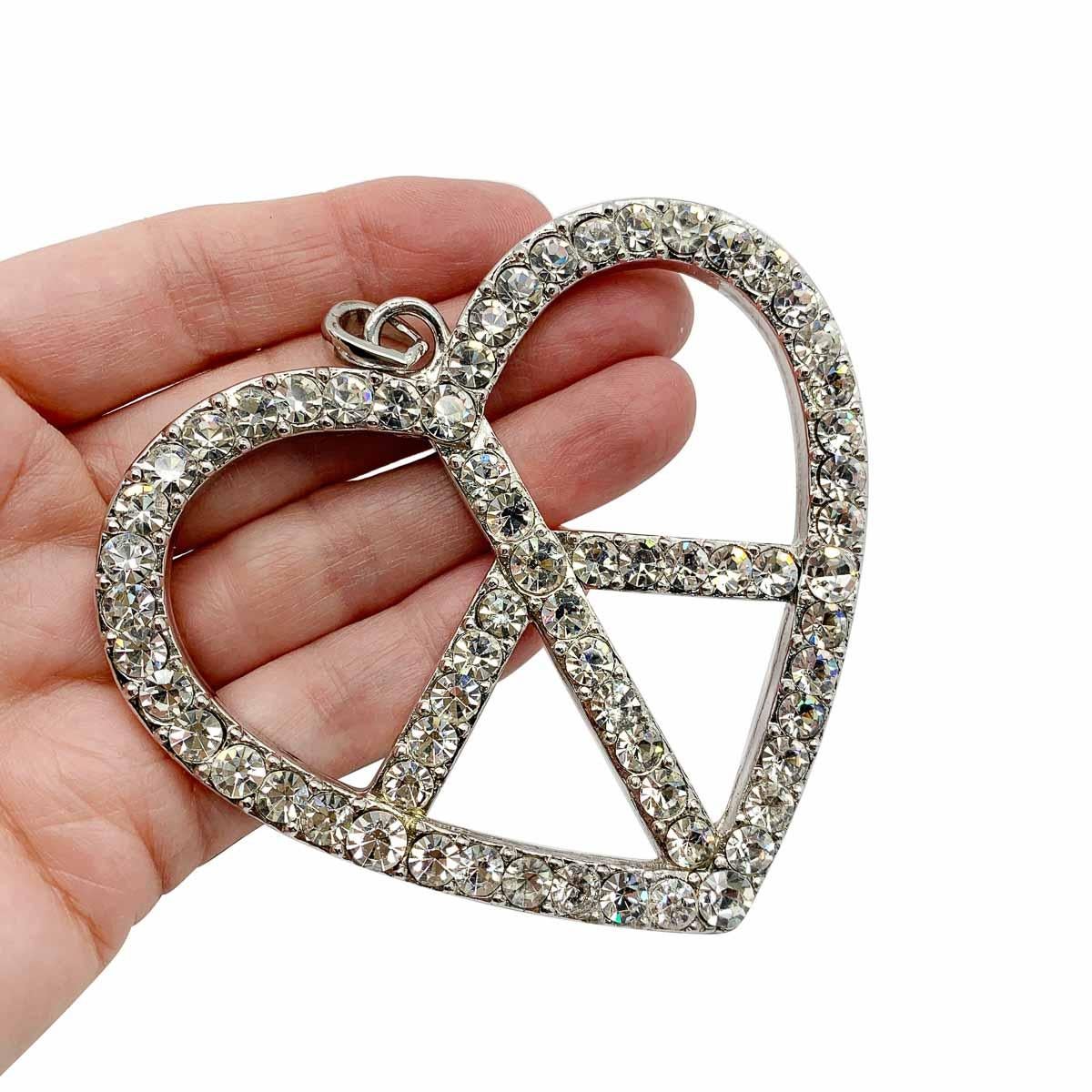 Harking back to the 80's with a serious Madonna vibe. A gigantic vintage Peace pendant. Featuring end to end crystals in a statement size heart inspired peace symbol.

Vintage Condition: Very good without damage or noteworthy wear.
Materials: Silver