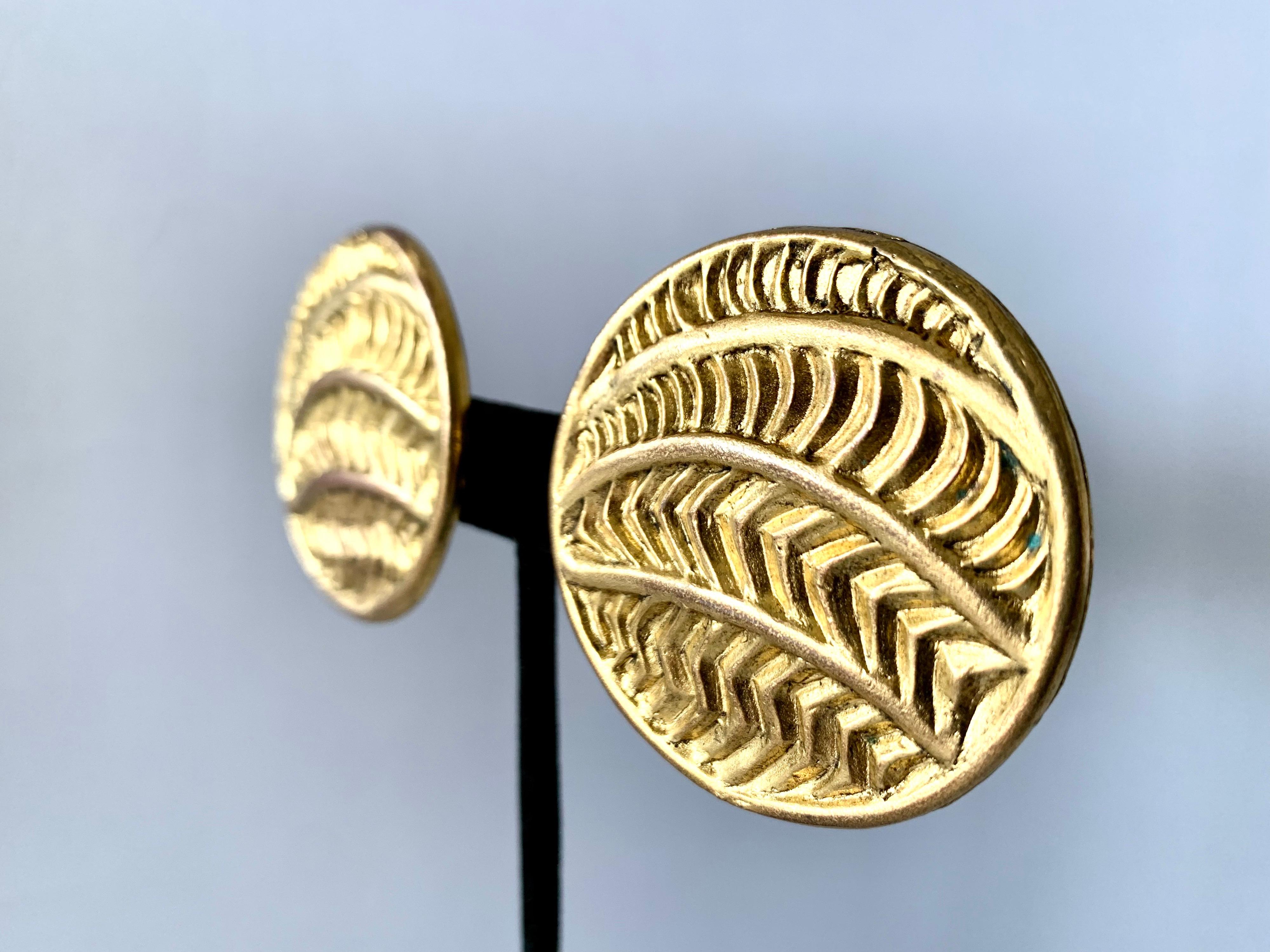 Vintage oversized round clip-on statement earrings comprised out of gilt metal featuring a carved tribal design. The earrings are signed Isabel Canovas, circa 1980-1990 made in France.

Isabel Canovas was a high fashion costume jewelry designer who