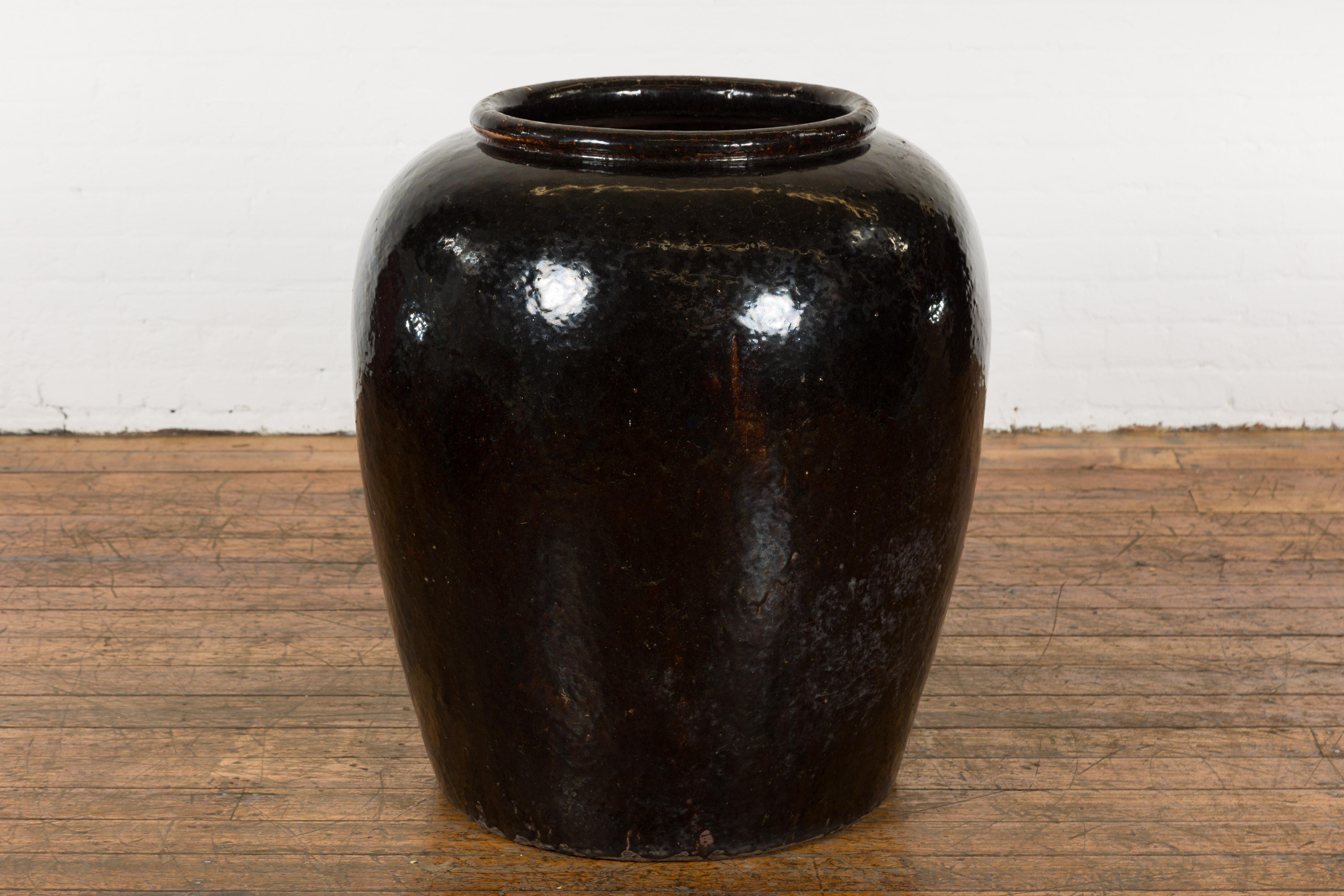 Ein übergroßer, schwarz glasierter Thai-Pflanztopf aus Keramik aus der Mitte des 20. Jahrhunderts mit braunen Akzenten. Dieses große Pflanzgefäß wurde in der Mitte des Jahrhunderts in Thailand hergestellt. Es hat eine runde Öffnung mit einer dünnen