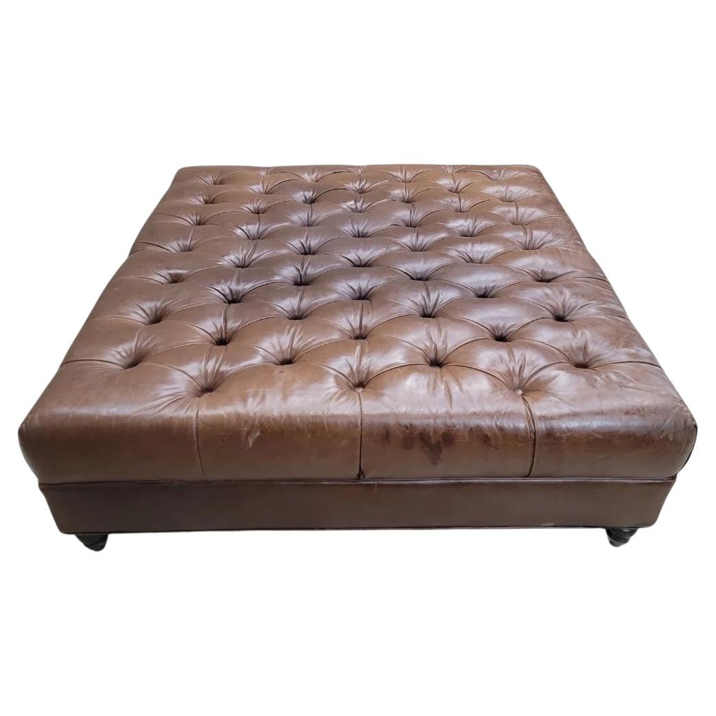 Otomana/mesa de café vintage de cuero envejecido y acolchado sobre patas torneadas