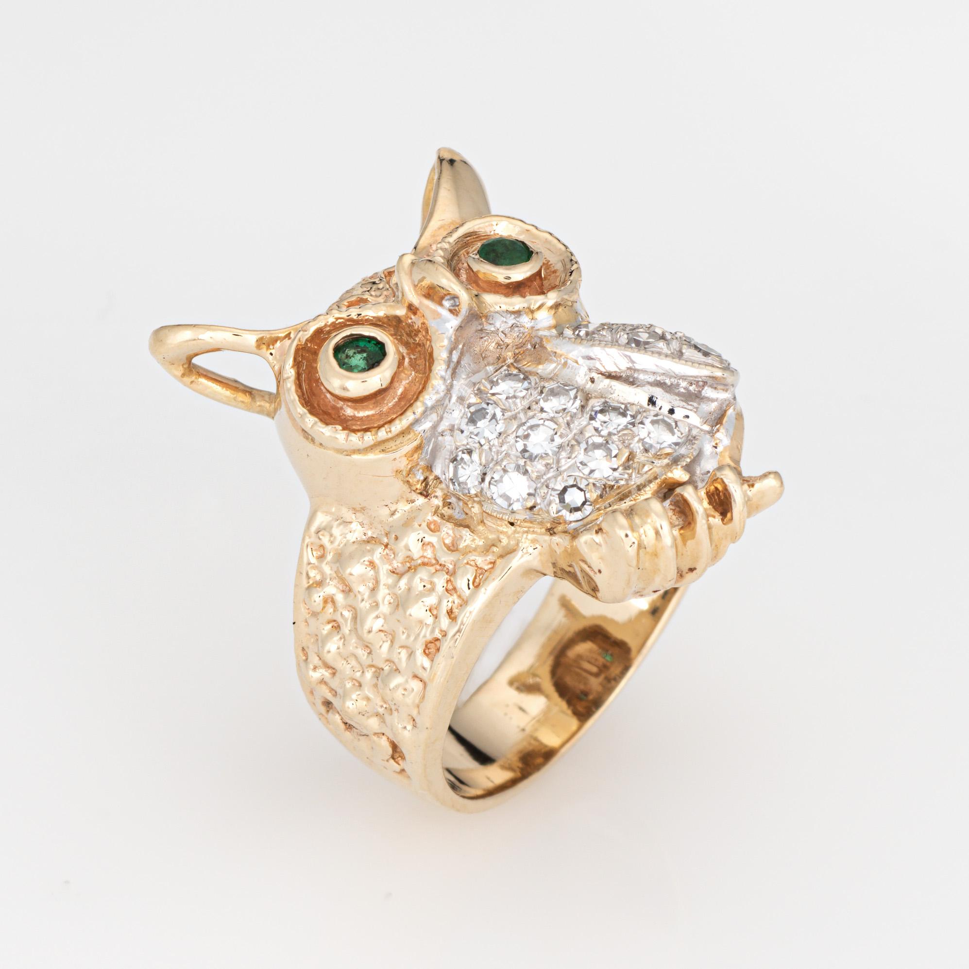 Finley detailed owl ring set with diamonds and green emerald eyes, crafted in 14 karat yellow gold (circa 1970s). 

Single cut diamonds total an estimated 0.12 carats (estimated at H-I color and VS2-SI2 clarity). Two small emeralds measure approx.