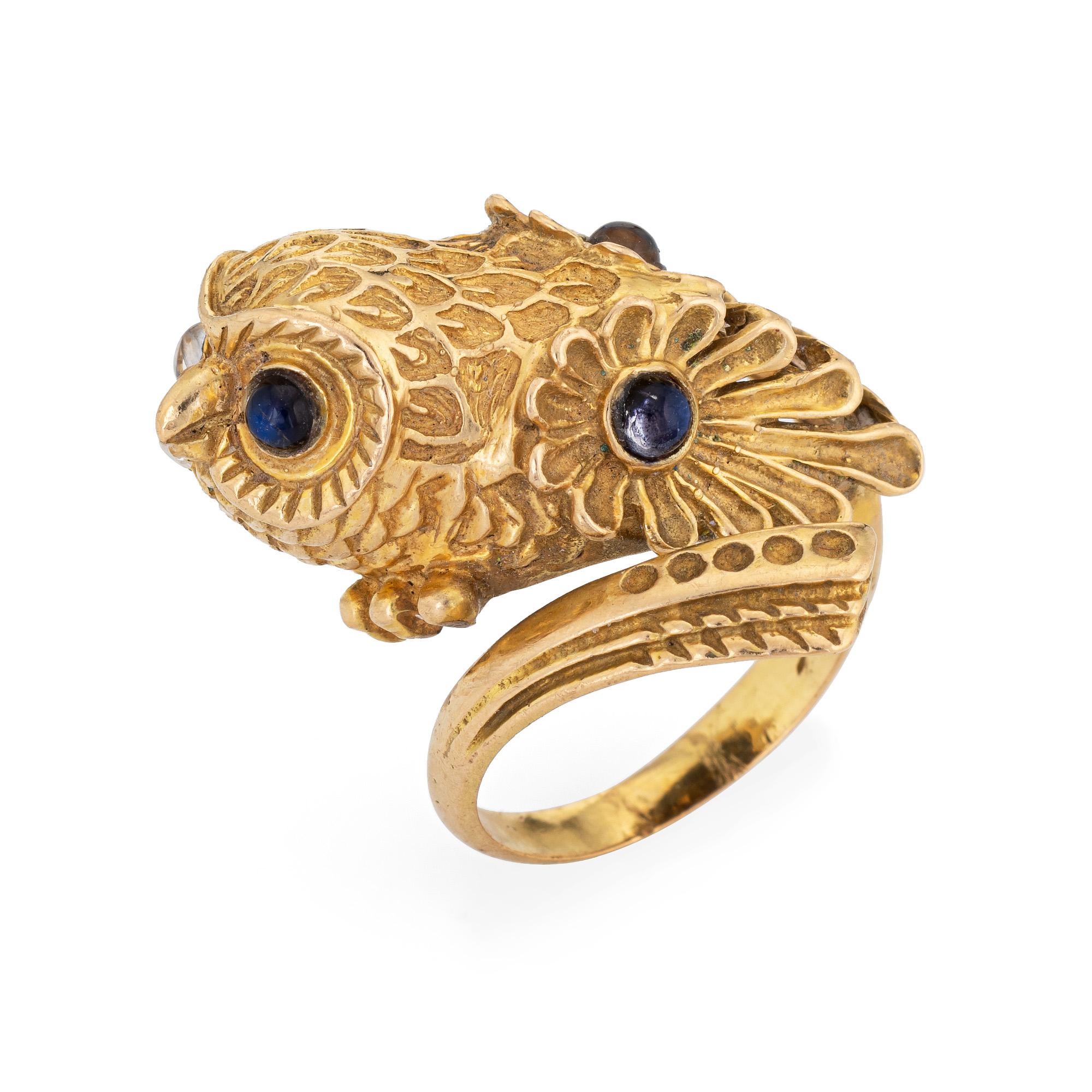 Distinct owl ring set with blue sapphire eyes crafted in 18 karat yellow gold (circa 1960s). 

Cabochon cut sapphires each measure 2mm (4 total). The sapphires are in very good condition and free of cracks or chips. 

The beautifully detailed owl is