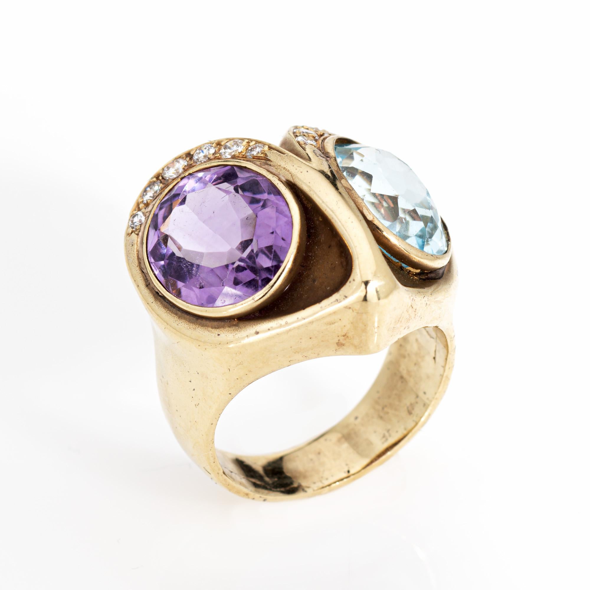 Distinct stylized owl ring set with amethyst and blue topaz, crafted in 14 karat yellow gold (circa 1970s to 1980s). 

Blue topaz and amethyst measures 12mm x 9mm. 12 diamonds total an estimated 0.08 carats (estimated at H-I color and SI1-2