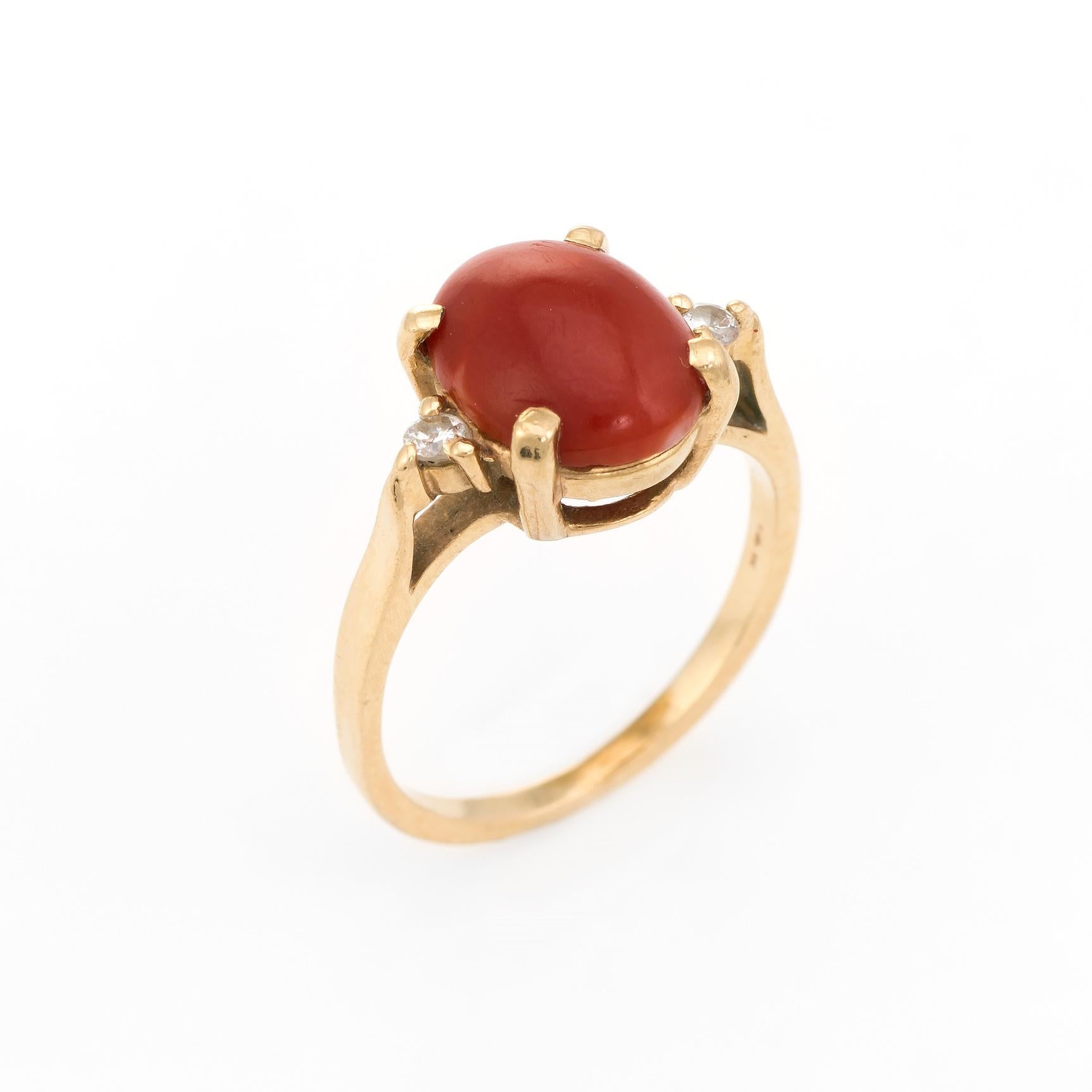 Finely detailed vintage ox blood coral & diamond cocktail ring, crafted in 14 karat yellow gold. 

Centrally mounted ox blood coral measures 10mm x 8mm (estimated at 3.50 carats), accented with two estimated 0.03 carat round brilliant cut diamonds.