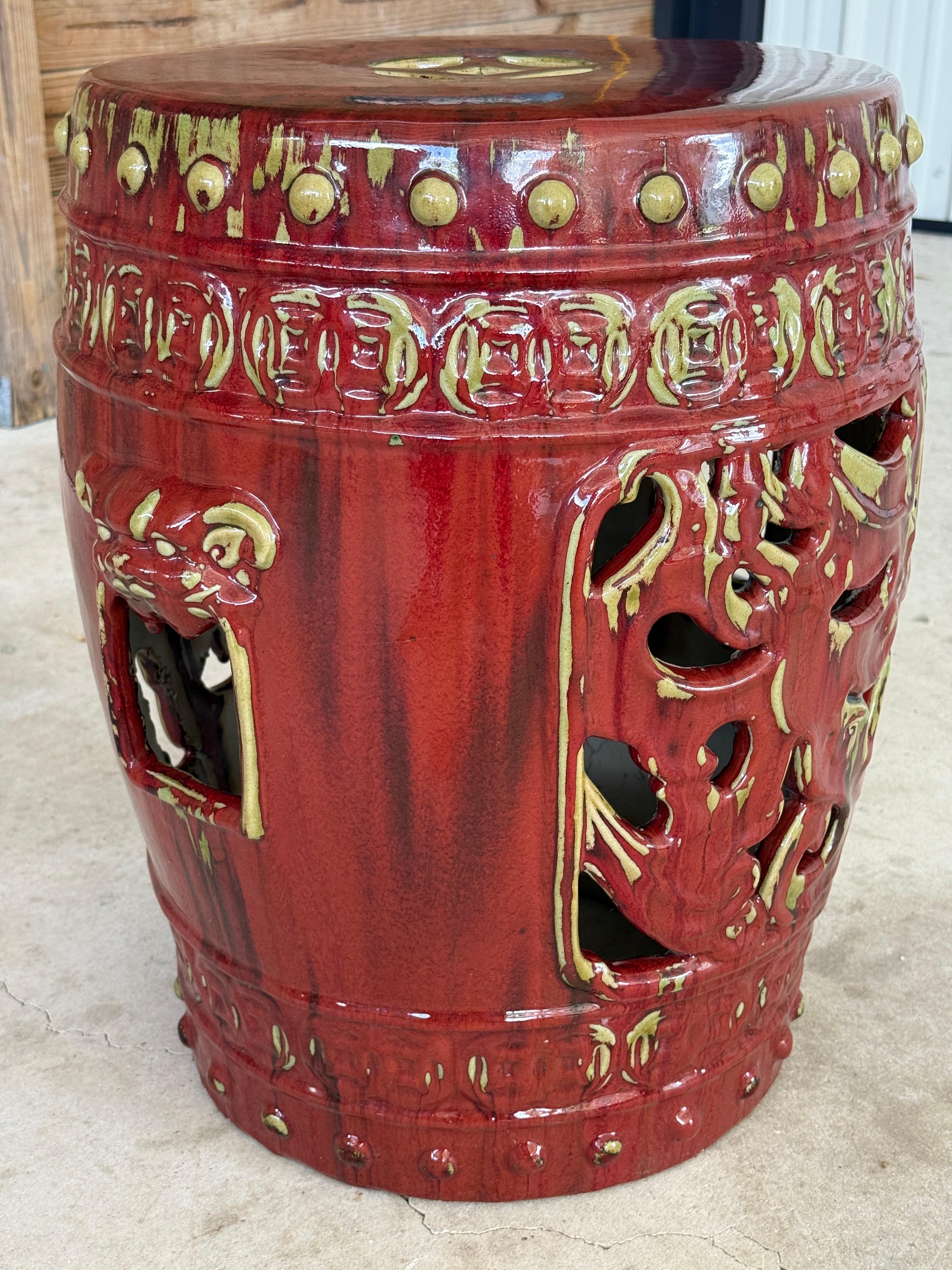 Llamativo taburete de jardín de cerámica china de época, en un rico vidriado rojo sangre de buey con matices mostaza, con intrincados detalles perforados y motivos de máscaras de león.
El diseño incluye los tradicionales recortes de monedas y