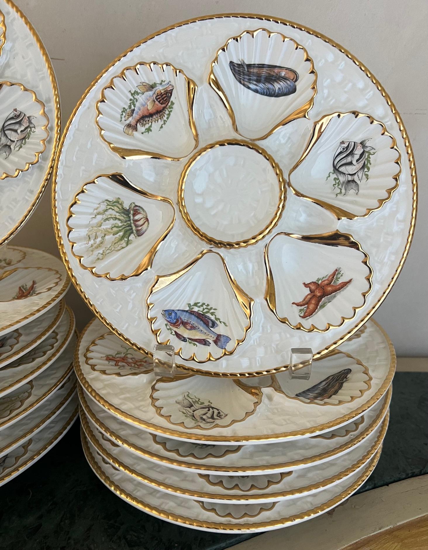 Ceramic oyster / seafood plate includes six wells each with a different sea creature lined in gold paint. The center well is raised and useful for lemon wedges.