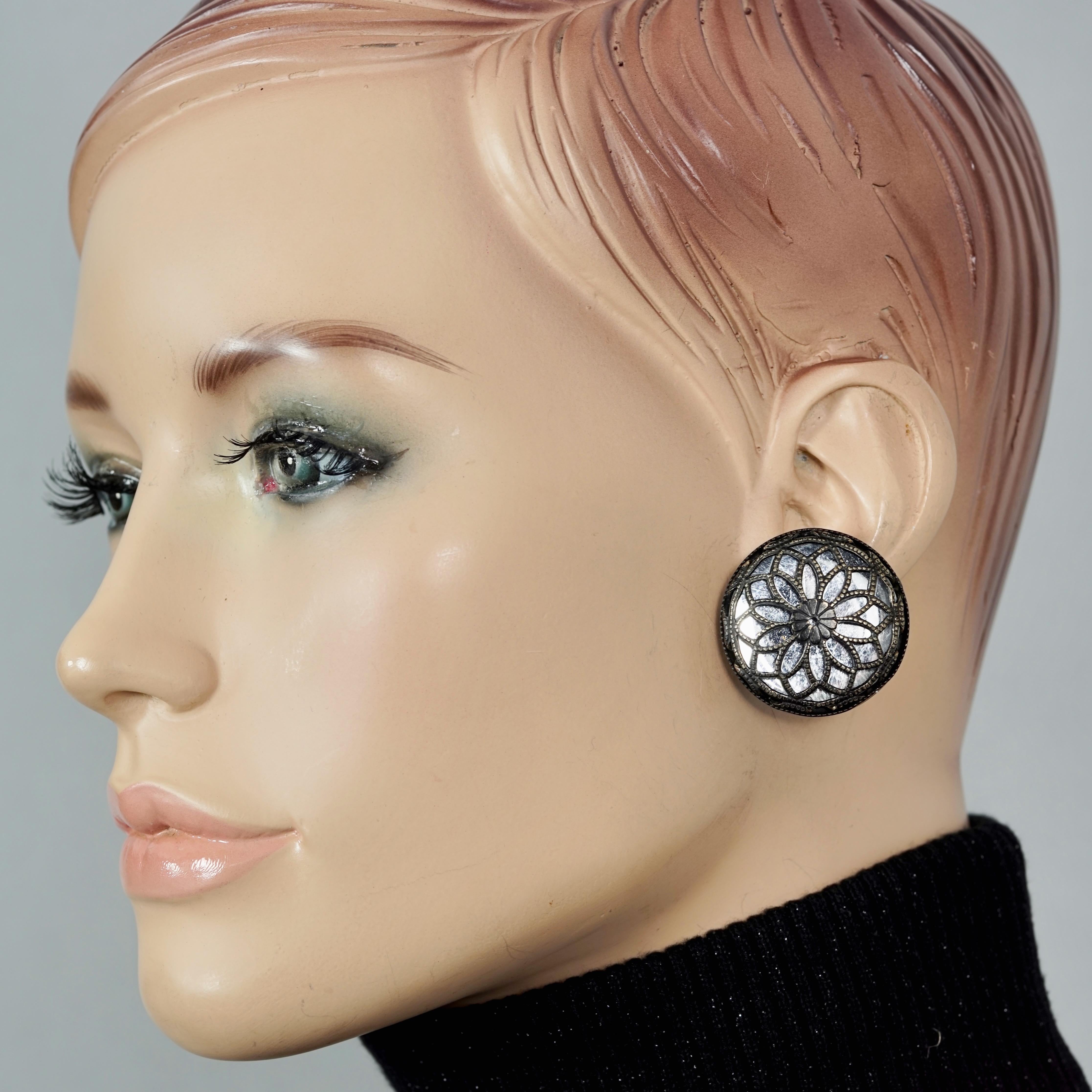 Vintage PACO RABANNE Cutout Flower Mirror Disc Earrings

Measurements:
Height: 1.22 inches (3.1 cm)
Width: 1.22 inches (3.1 cm)
Weight per Earring: 9 grams

Features:
- 100% Authentic PACO RABANNE.
- Openwork flower mirror earrings.
- Gunmetal tone