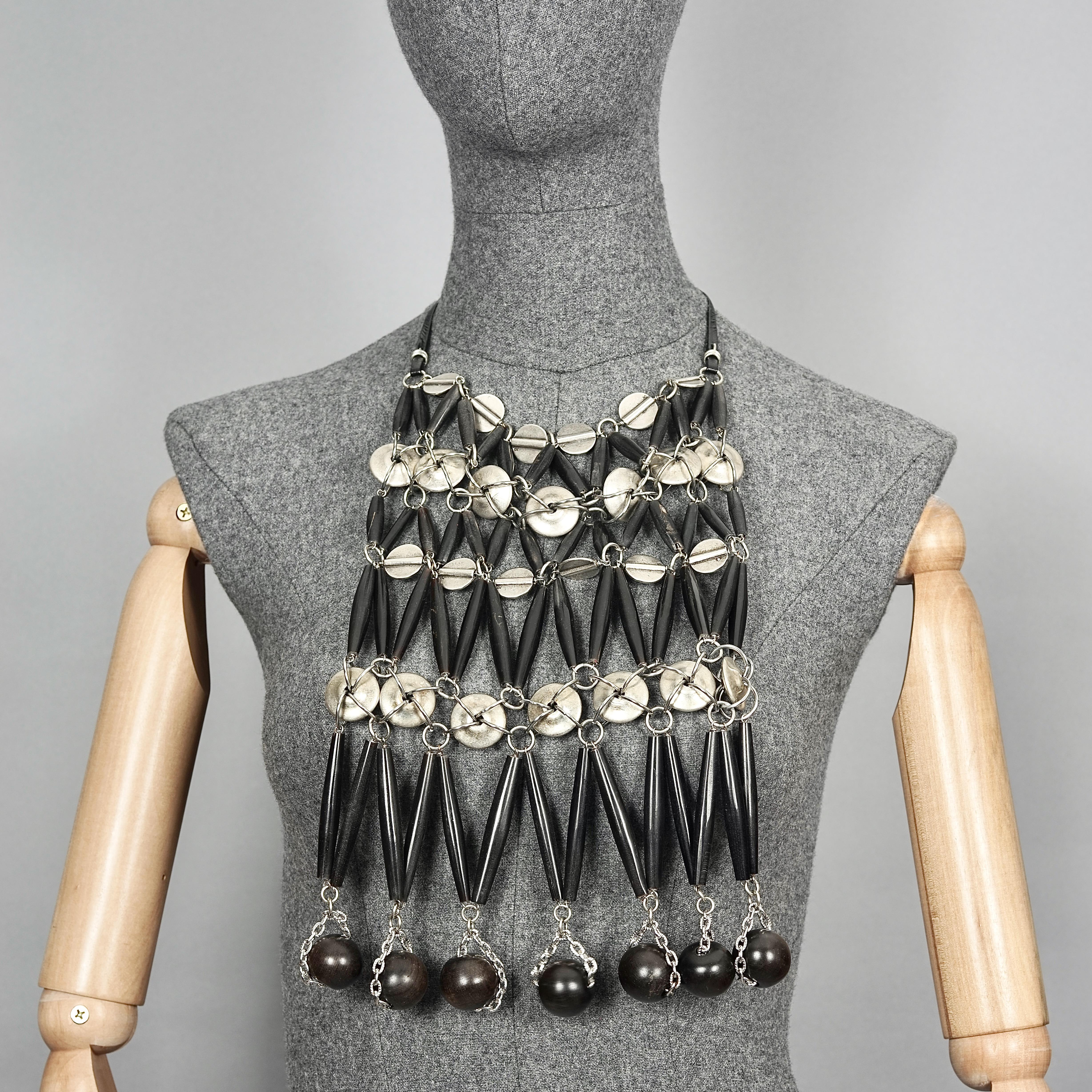 Vintage PACO RABANNE Ebony Wood, Horn Olives and Metal Disc Plastron Bib Necklace

Measurements:
Height: 11.81 inches (30 cm)
Width: 7.87 inches (20 cm)

Features:
- 100% Authentic PACO RABANNE.
- Ebony wood beads, horn olives and metal disc