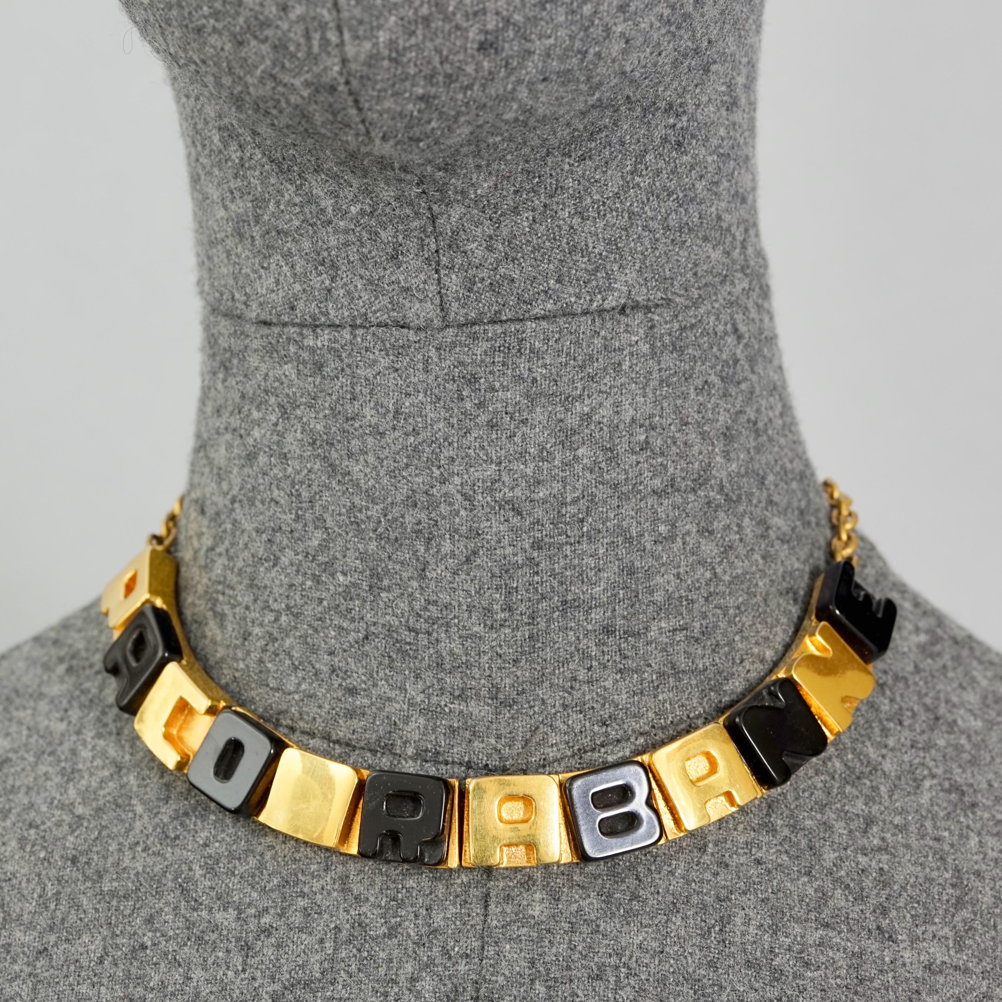 Vintage PACO RABANNE Gold Black Cube Letter Necklace

Measurements:
Height: 0.59 inch (1.5 cm)
Wearable Length: 14.96 inches (38 cm) Adjustable

Features:
- 100% Authentic PACO RABANNE.
- Cube letter charms spelled PACO RABANNE.
- Gold and black