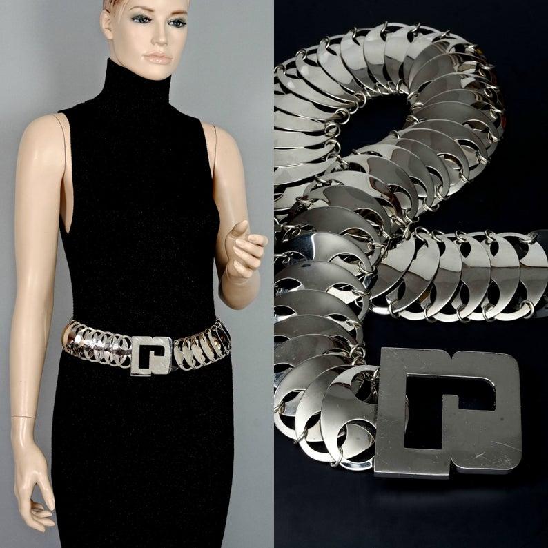 Vintage PACO RABANNE Logo Metal Disc Space Age Belt

Measurements:
Buckle Height: 2.59 inches (6.6 cm)
Belt Height: 2.16 inches (5.5 cm)
Overall Length: 32.28 inches (82 cm)

Features:
- 100% Authentic PACO RABANNE.
- Massive R buckle.
- Overlapping