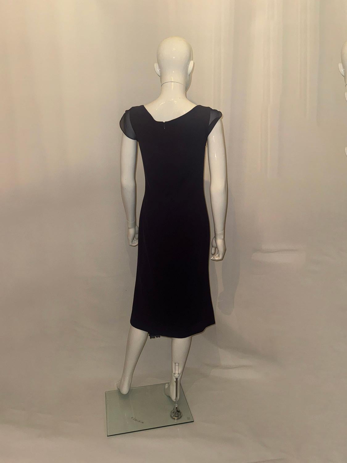 Un abito vintage di Paddy Campbell, elegante e facile da indossare. In un meraviglioso crêpe di lana e in un grazioso color prugna, l'abito ha una scollatura a palloncino, con dettagli in seta sulle spalle e un inserto in basso a destra. Ha una zip