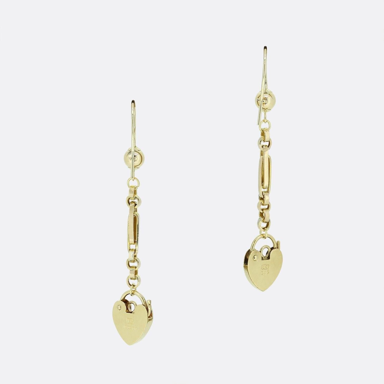 This is a pair of vintage 9ct yellow gold drop earrings. Each earring features a padlock charm that sits at the bottom of the fancy chain.

Condition: Used (Very Good)
Total Weight: 3.2 grams
Earring Dimensions: 45mm x 10mm (Height x