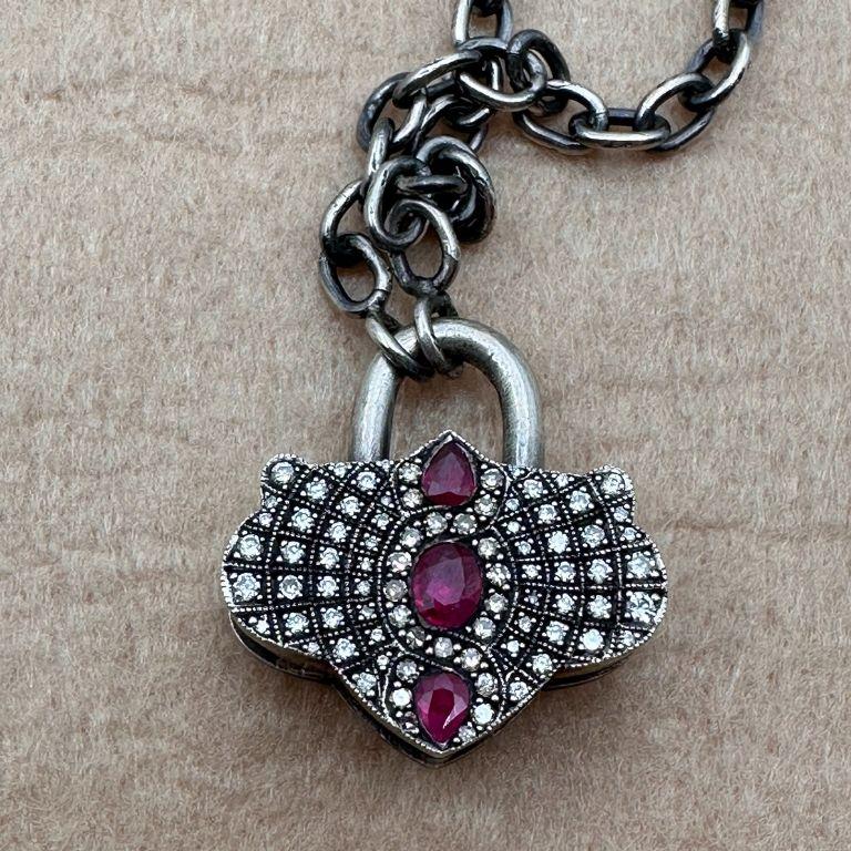 -Cette pièce se distingue par son design vintage unique, son motif de cadenas et son mélange exquis de pierres précieuses de haute qualité.
-Fabriqué avec des matériaux rares tels que des diamants cognac et des rubis, dans le cadre d'un travail