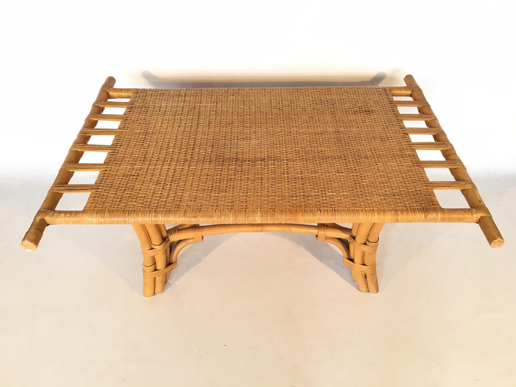 Bamboo coffee table features ornate hand-formed structure and cane woven rattan top and bindings. Excellent vintage condition with minor abrasions consistent with age.