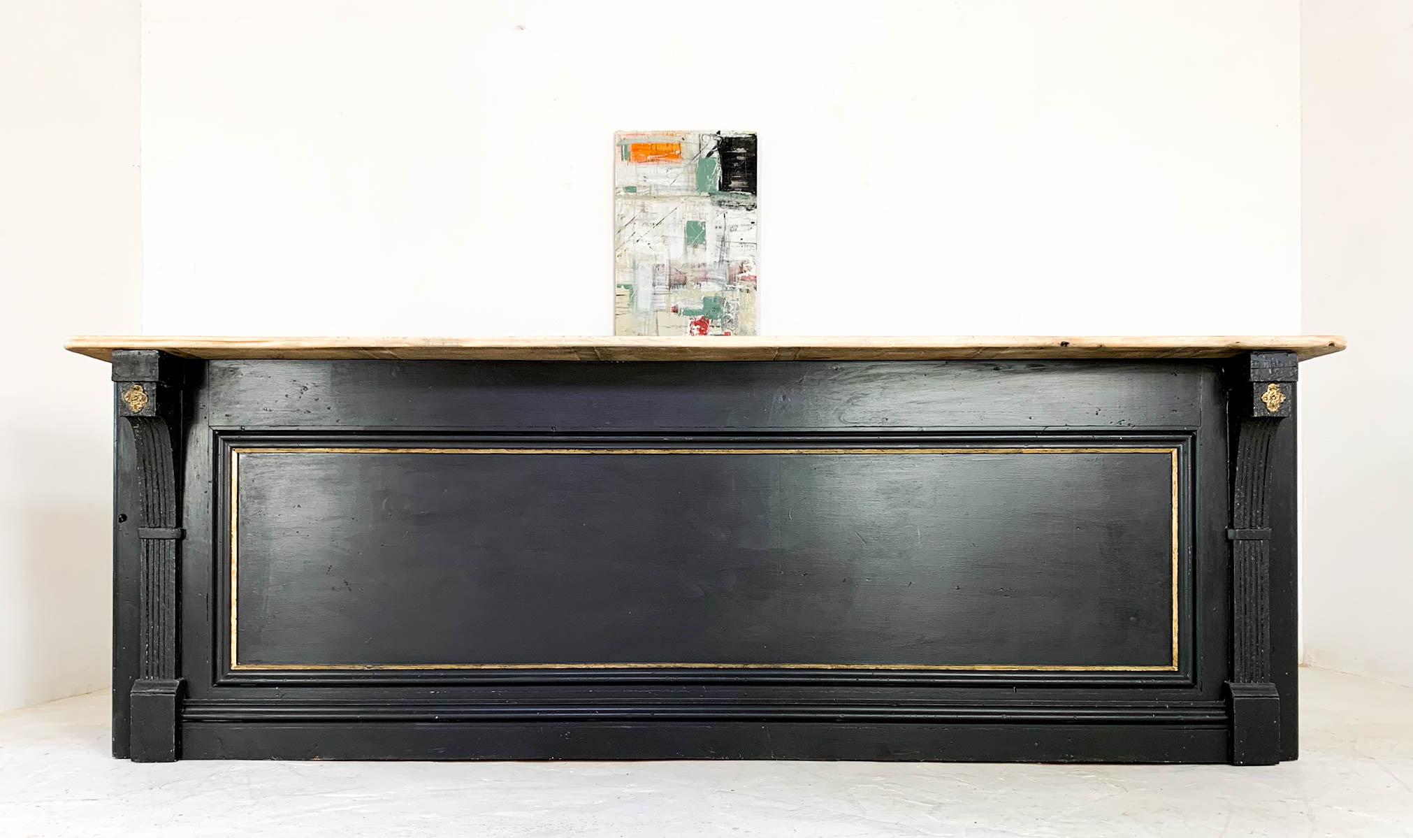 Stunning pine shop counter which has been fully restored to bring it back to it's former glory. The paneled front features decorative corbels at either end and gold paint that highlights and details the moldings. The top is a later addition made