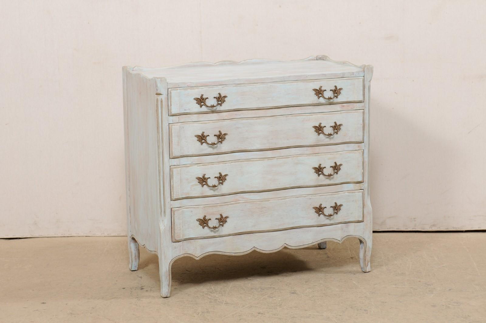 An American carved and painted wood four-drawer chest from the mid 20th century. This vintage American chest features a rectangular-shaped top with sweetly scalloped raised lip along the sides and back, atop a case which houses four drawers, each