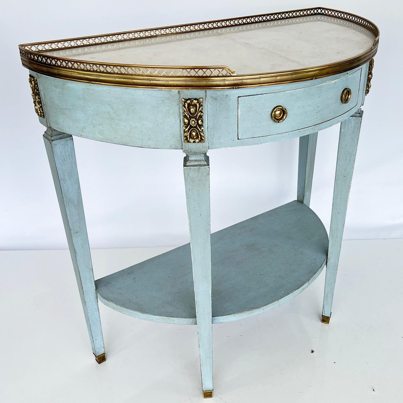 Demilune console, having a top of Carrara marble with 3/4 gallery of pierced brass, on conforming table base, painted in light-blue, showing natural wear; the single frieze drawer with post and ring handles, flanked by cartouches, raised on four,