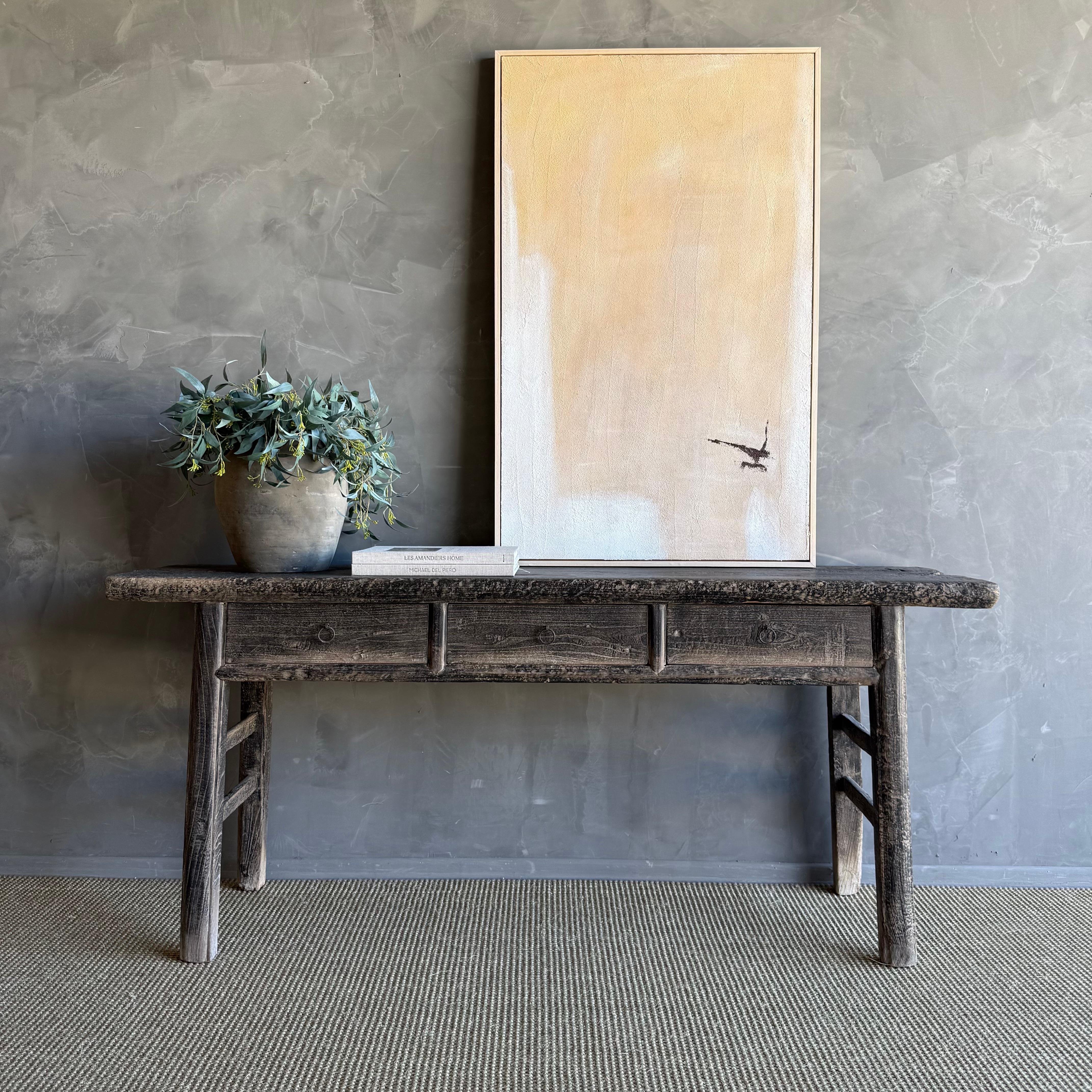 This charming vintage elm wood console is a one-of-a-kind piece with beautiful age and patina that adds character to any space. Its patina painted elm wood finish showcases the natural beauty of the wood, while the solid elm wood original hardware