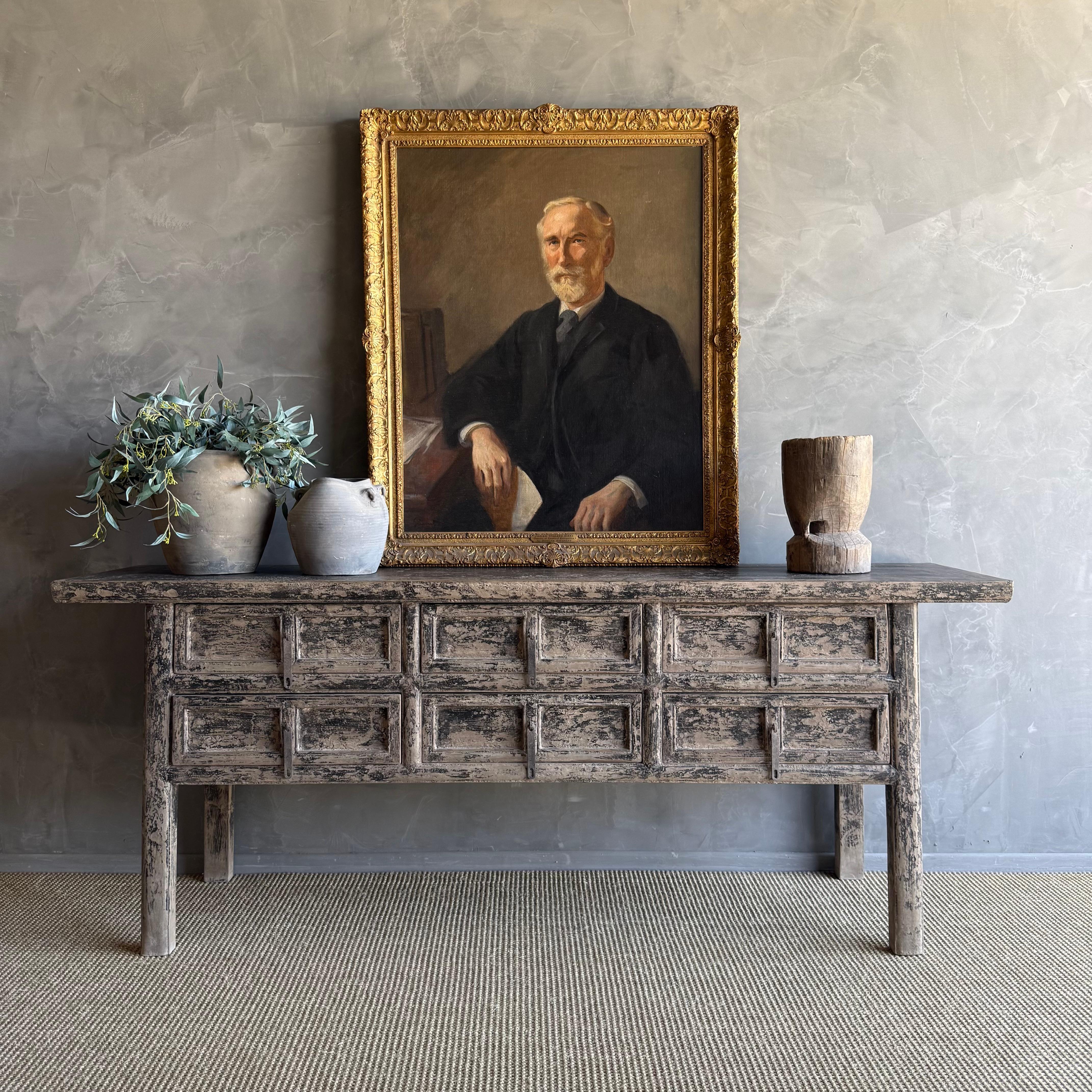 This charming vintage elm wood console is a one-of-a-kind piece with beautiful age and patina that adds character to any space. Its patina painted elm wood finish showcases the natural beauty of the wood, while the solid elm wood original hardware