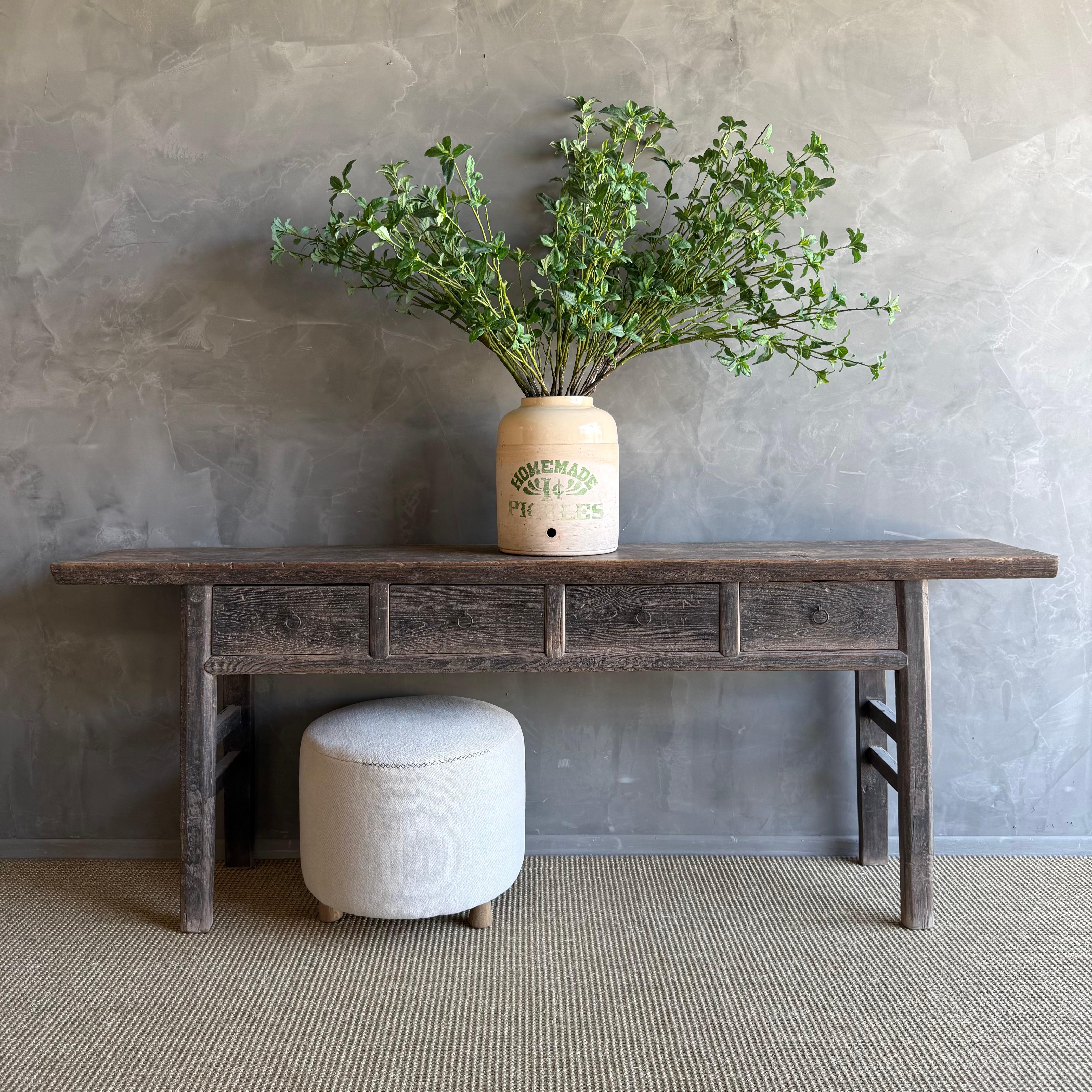 This charming vintage elm wood console is a one-of-a-kind piece with beautiful age and patina that adds character to any space. Its patina painted elm wood finish showcases the natural beauty of the wood, while the solid elm wood original hardware